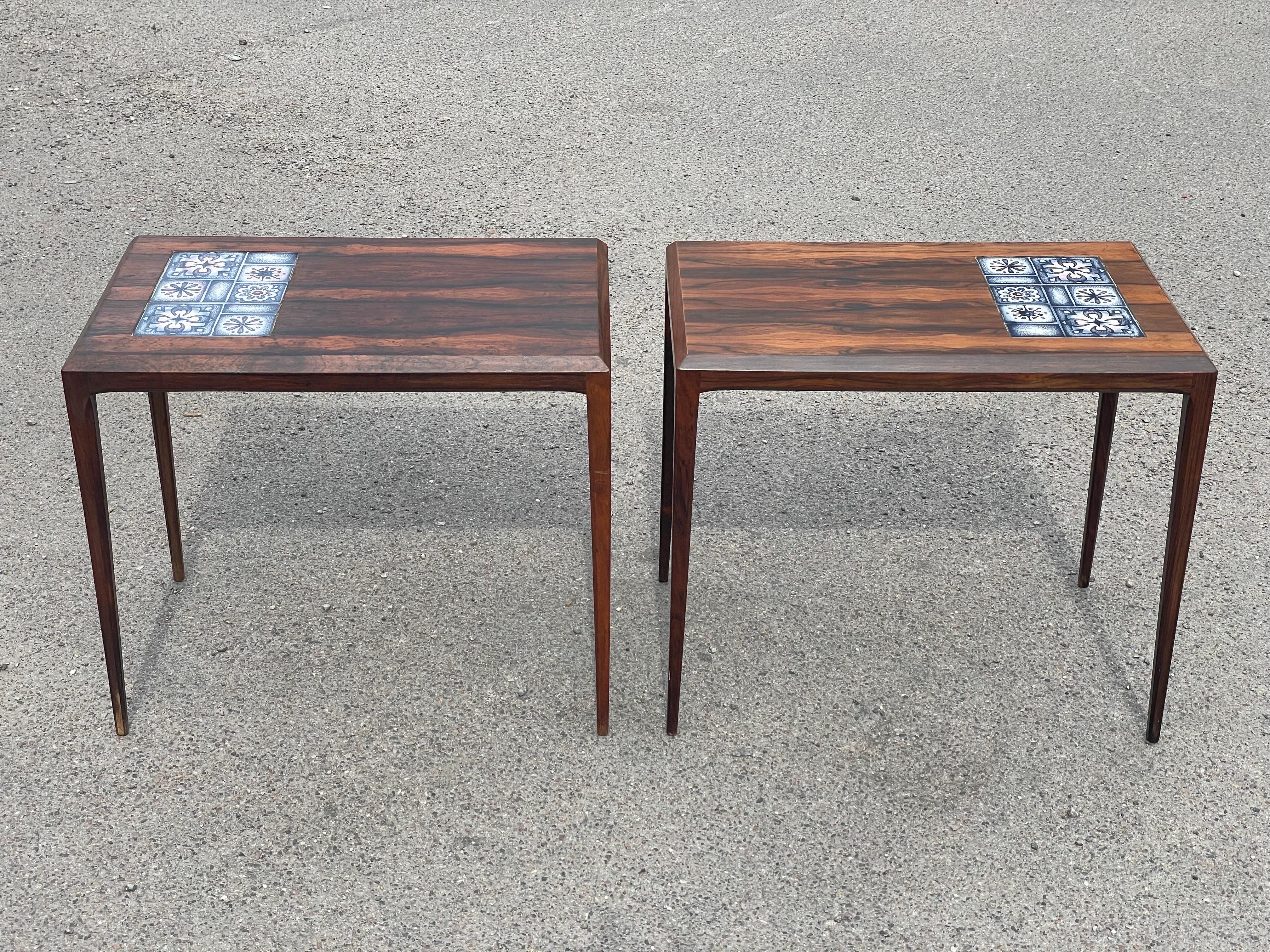 a timeless treasure from the 1960s: a stunning pair of rosewood side tables with Faience tile tops crafted by the renowned Severin Hansen. Manufactured by the esteemed Haslev Møbelfabrik in Denmark, these tables boast exquisite tiles made by none