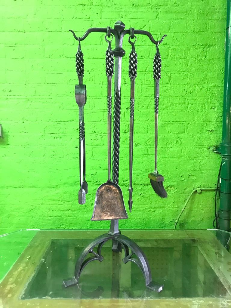 A 19th century set of Gothic Style fire tools handmade with decorative weaved handles. On original gothic stand, complete with fire tongs, shovel, brush and poker.
 