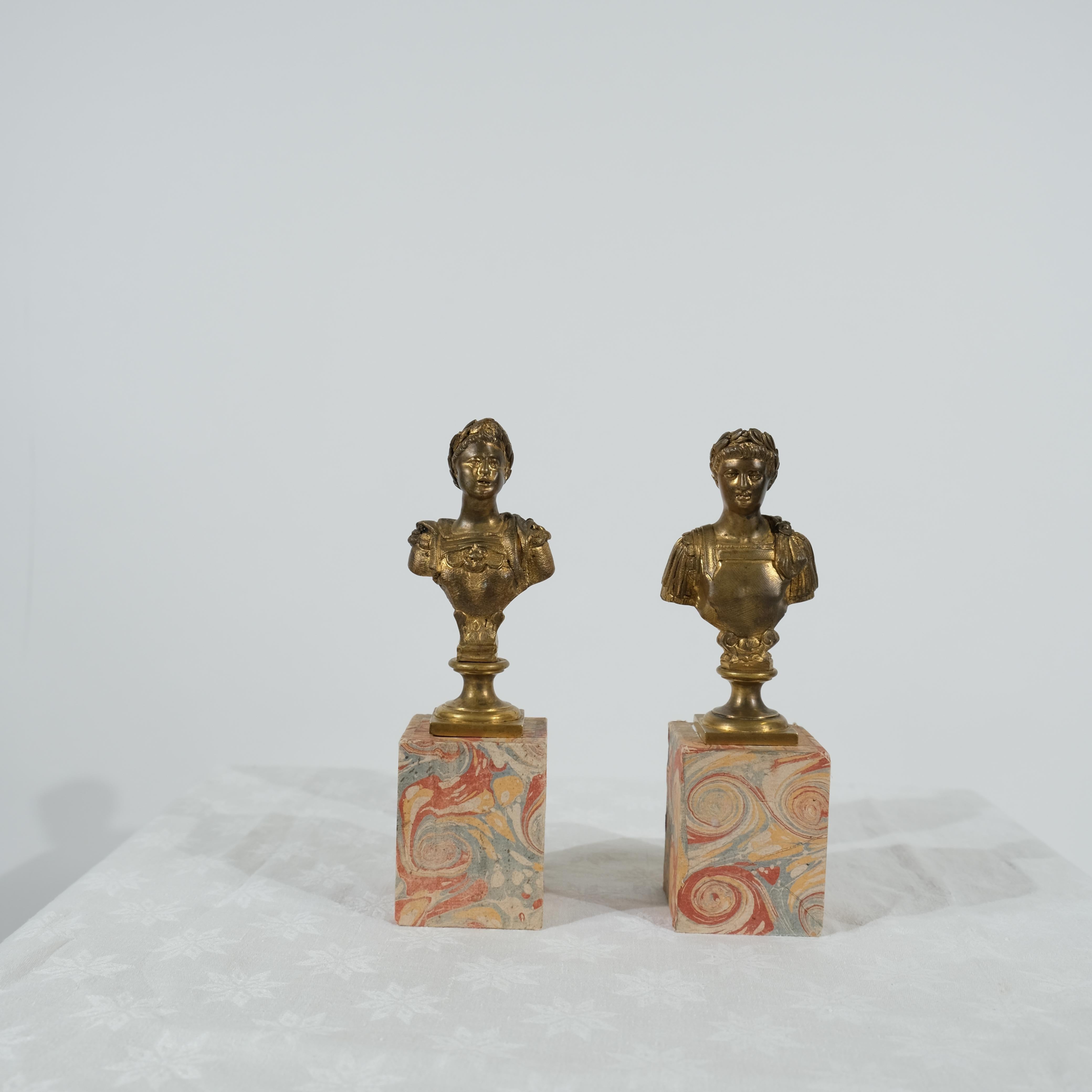 Questa coppia di piccoli busti Grand Tour è realizzata in bronzo dorato e presenta dettagli intricati che riflettono le influenze del design classico. Ogni busto presenta una meravigliosa patina che aggiunge un tocco di eleganza e carattere