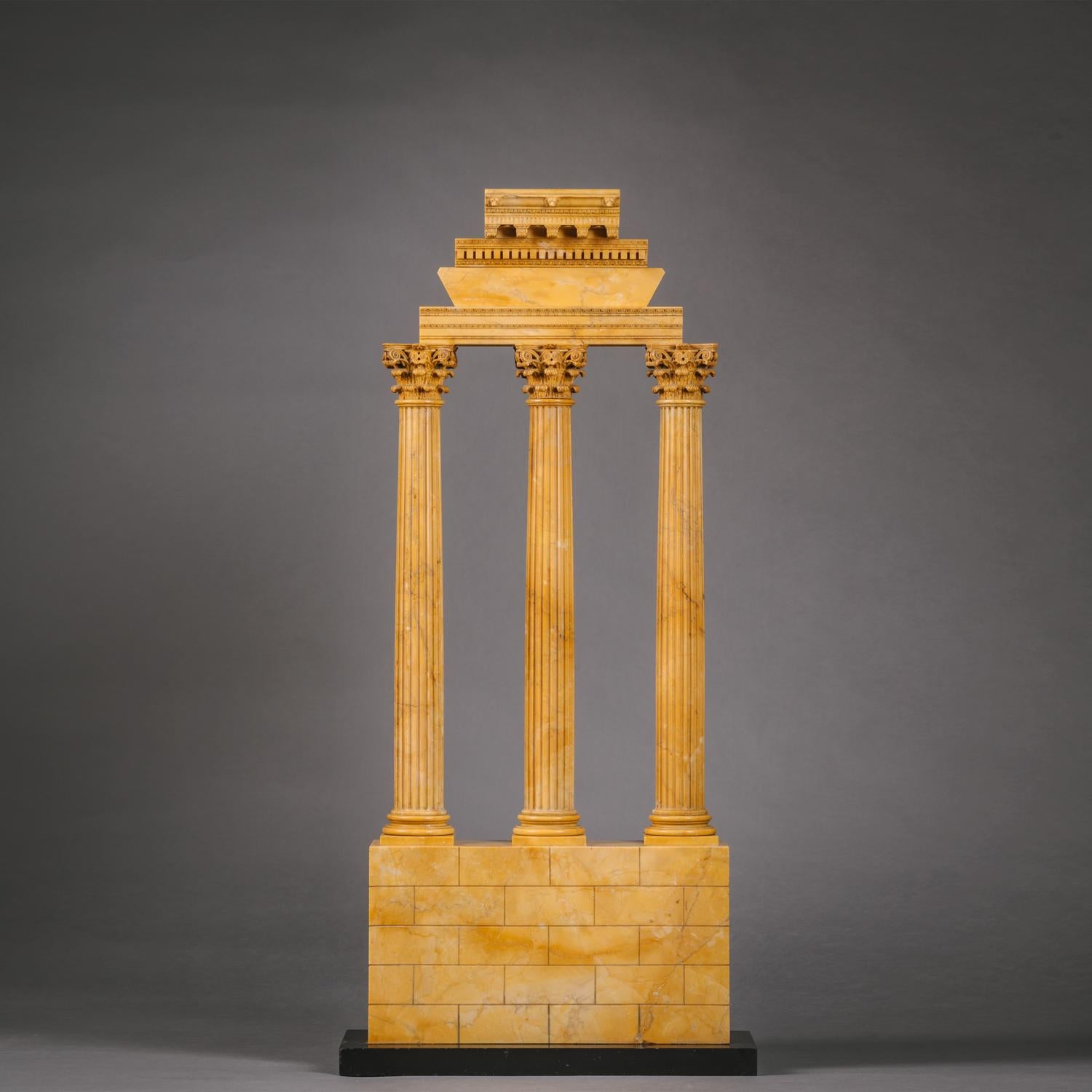 A Large Pair of Giallo Antico Marble ‘Grand Tour’ Models of Ruins Celebrating the Corinthian Order, Attributed To The Workshop Of Benedetto Boschetti.

The Temple of Castor and Pollux of flat section with three Corinthian columns supporting inverted