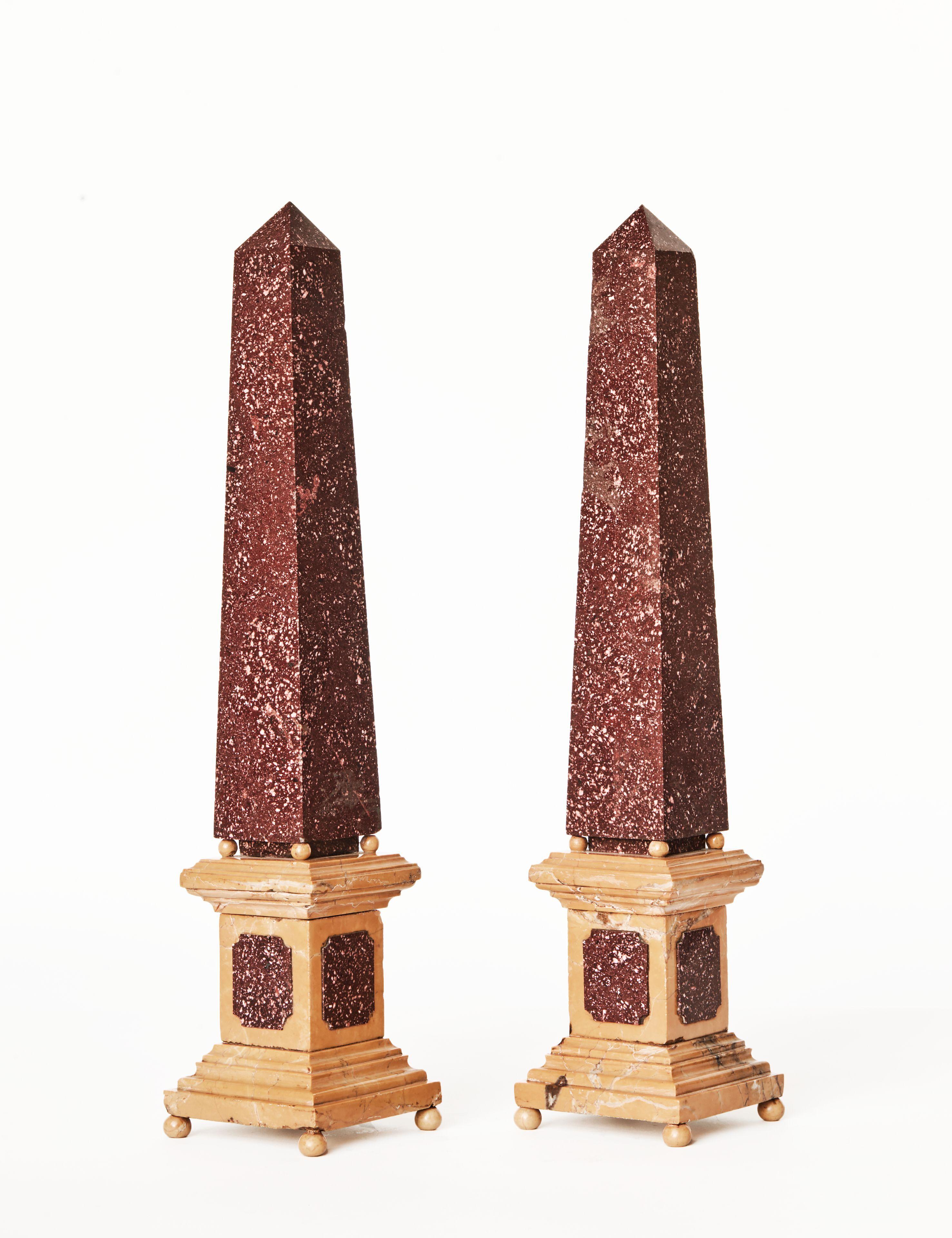 The porphyry obelisks on sienna 'marmo giallo' and porphyry base, condition: 2 small cracks on 1 base and a repair to the other on top of base. Condition commensurate with age and use.