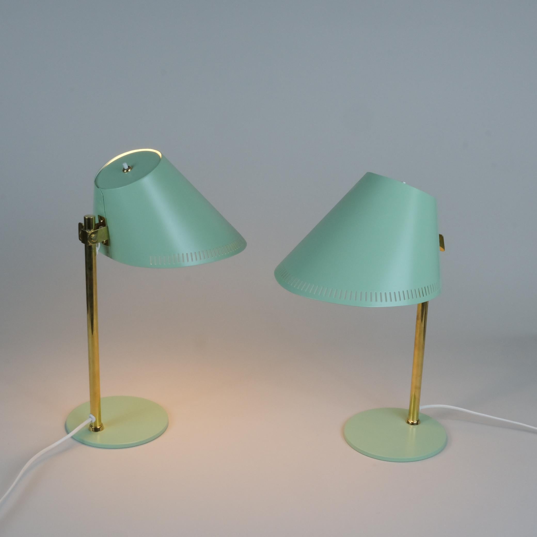 Une paire de lampes de table Paavo Tynell model. 9227 en métal peint en vert et en laiton, fabriquées par Idman Oy en Finlande dans les années 1950. Un exemple exquis d'un beau design classique avec des caractéristiques qui le rendent adapté à un