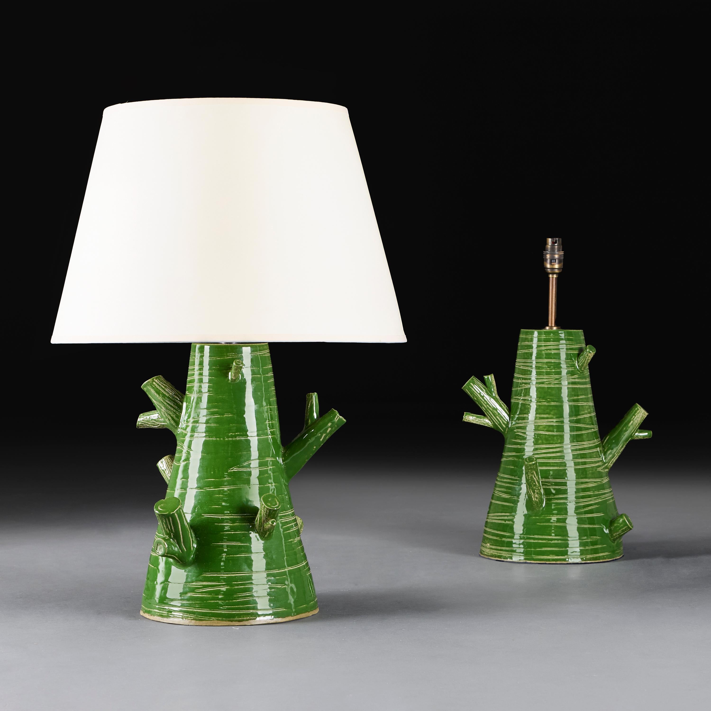 England, modern. 

A pair of art pottery tree trunk  lamps, the body with naturalistic sgraffito markings decorated in a green glaze. 

Height of vase 36.00cm
Height with shade 65.00cm.
Width of base 22.00cm.

Please note:

Lampshades not included.