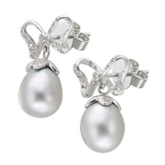 A pair of grey cultured pear and diamond bow earrings
