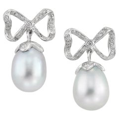 A pair of grey cultured pear and diamond bow earrings