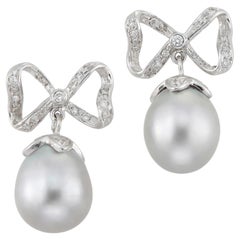 A pair of grey cultured pear and diamond bow earrings