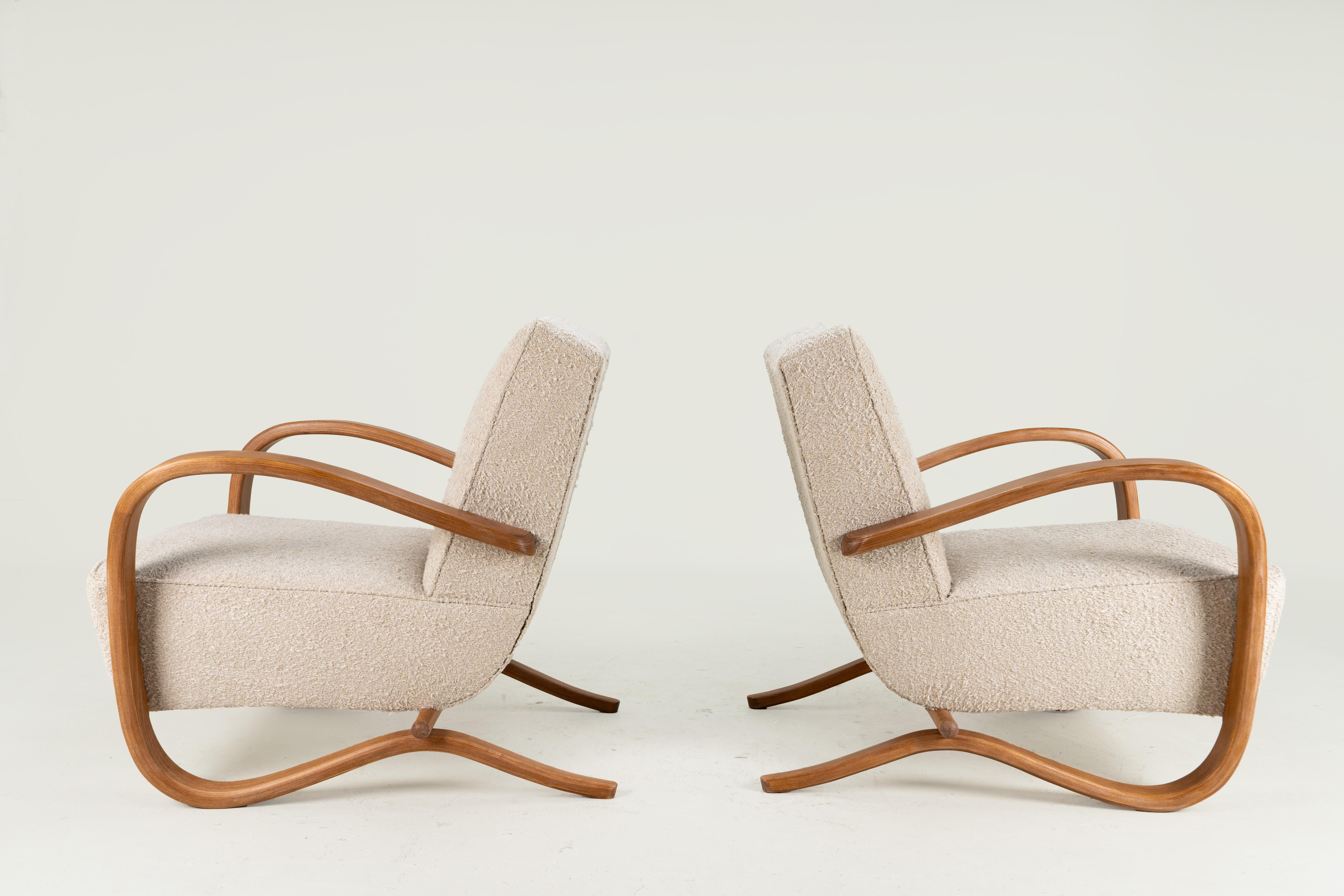 These sinuous and stylish armchairs are made in the style of Jindrich Halabala, a Czechoslovakian furniture designer and maker from Prague. Like the original H-269 design, these chairs feature solid beechwood arms that have been steamed and bent