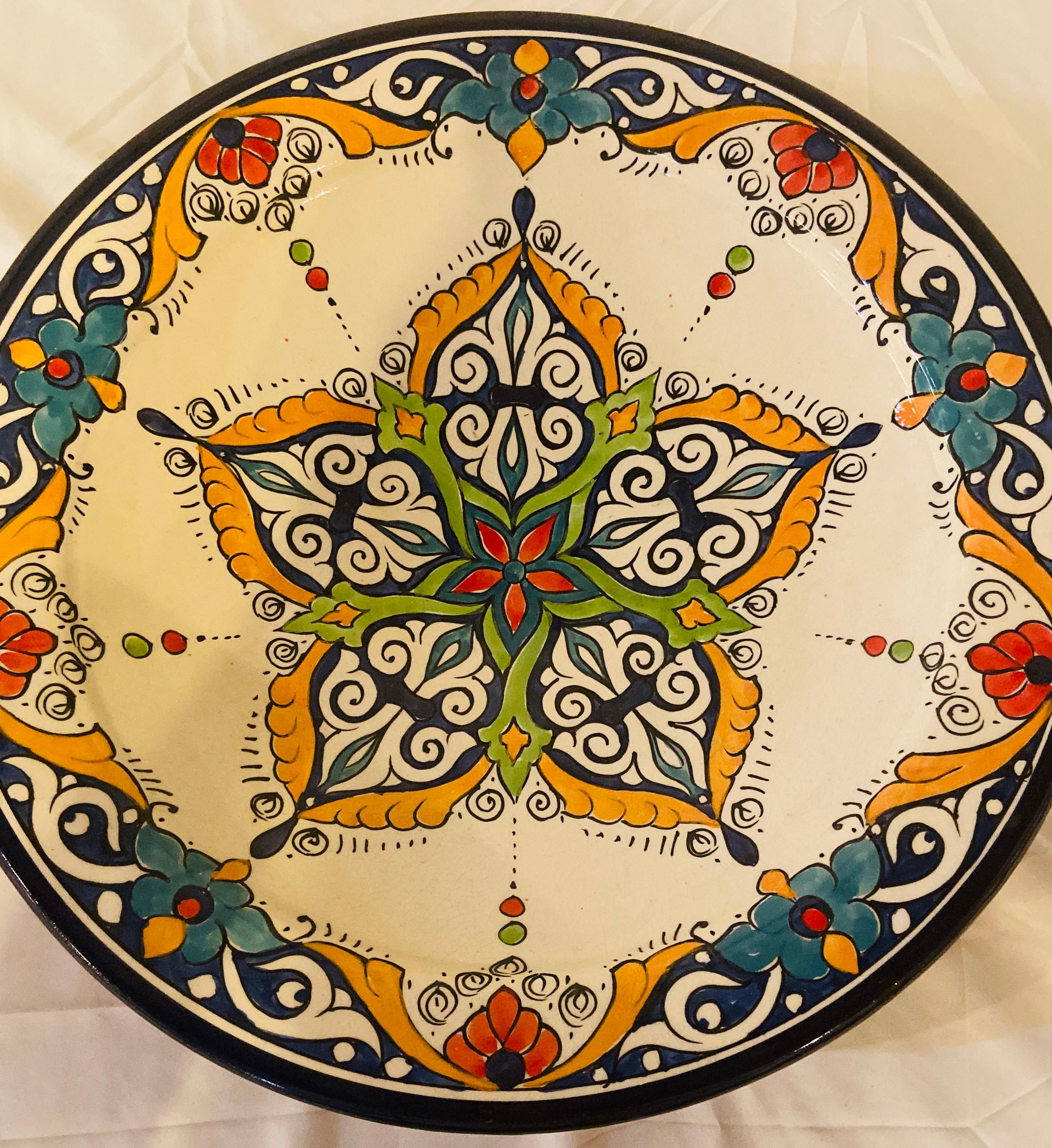 With a delightful floral and arabesque design hand painted in multiple colors in blue, yellow and red. This gorgeous, large-size ceramic dinner plate possesses a truly exotic look. Handcrafted in the bustling workshops of master artisans in the