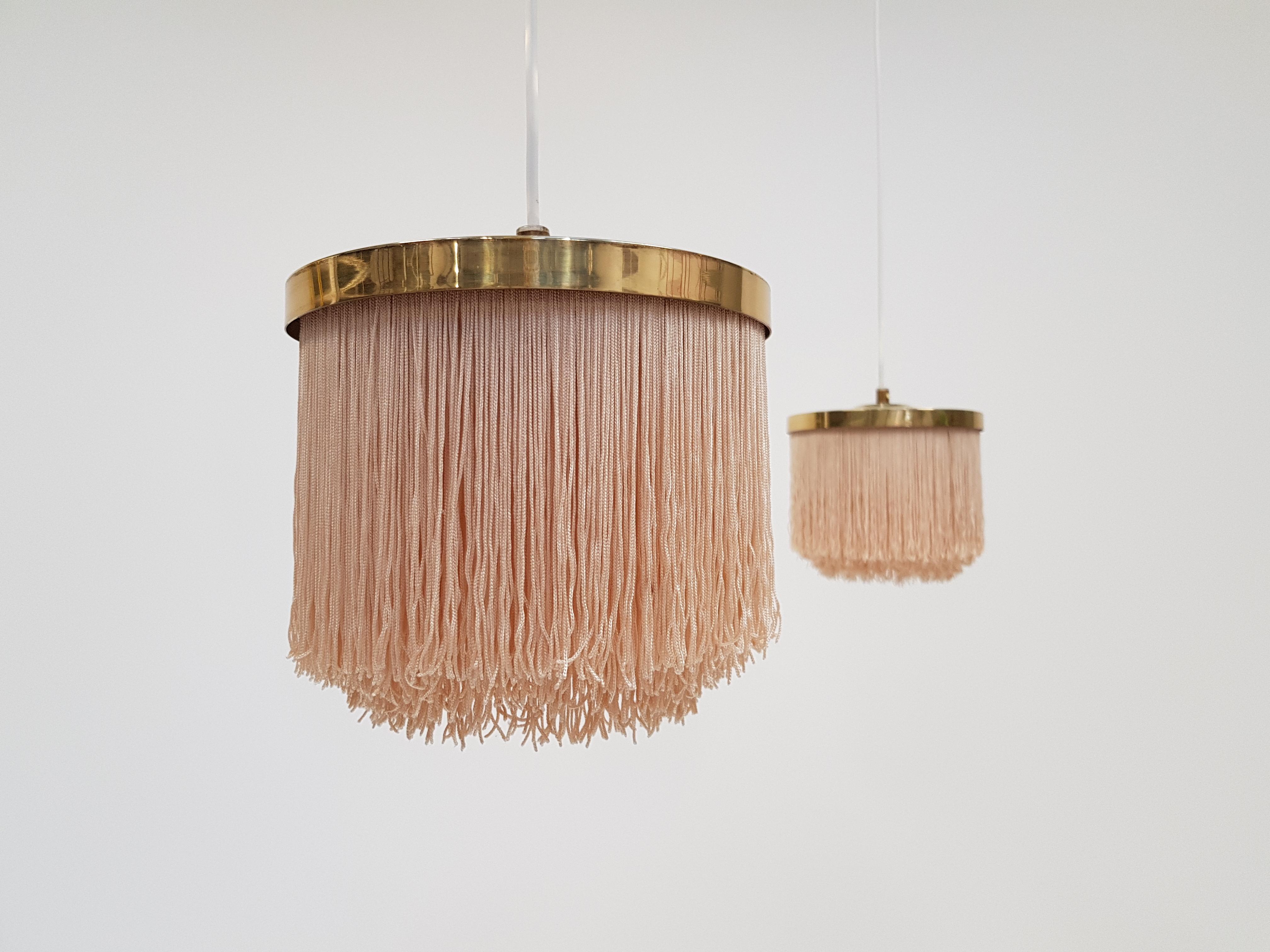 A pair of Hans-Agne Jakobsson for Markaryd taupe-colored silk fringed pendants with brass frame, dating from the 1960s and manufactured in Sweden.
 
Fully working, rewired, safety tested and passed - E27 / E26 Edison screw fitting.

Will