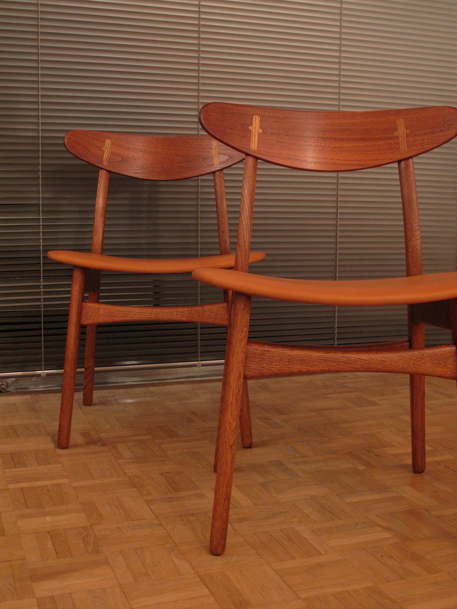 An exceptionally nice pair of Hans Wegner CH30 chairs just upholstered in premium quality tan leather. The color of the leather works perfectly with the honeyed Oak and contrasting teak backrests. We have kept the seat pads thin to accentuate the