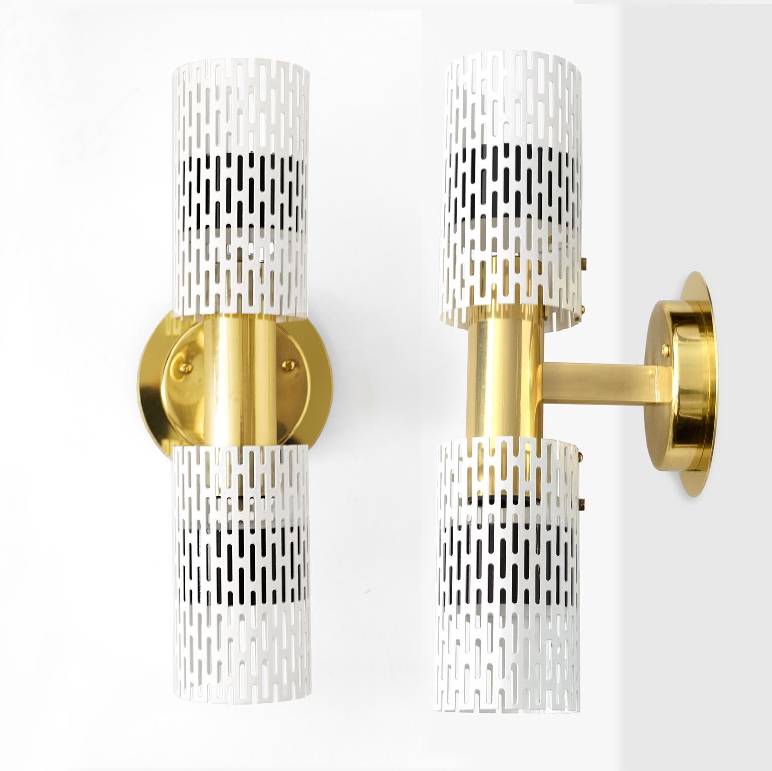 A pair of Harald Notini designed wall sconces with pieced tubular painted metal shades and polished brass frame and backplate. A custom brass element was created to allow easy installation for a standard American ‘J-box”. The sconces have been