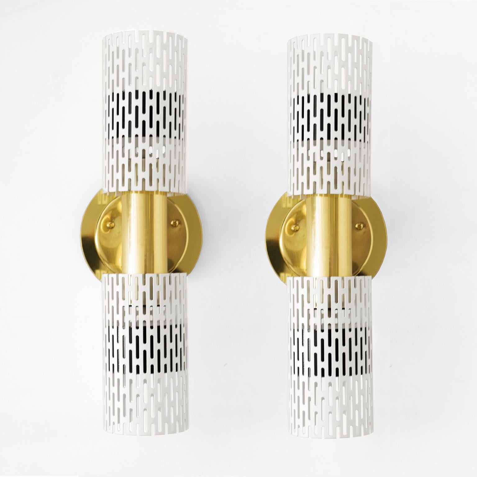 A pair of Harald Notini designed wall sconces with pieced tubular painted metal shades and polished brass frame and backplate. A custom brass element was created to allow easy installation for a standard American ‘J-box”. The sconces have been