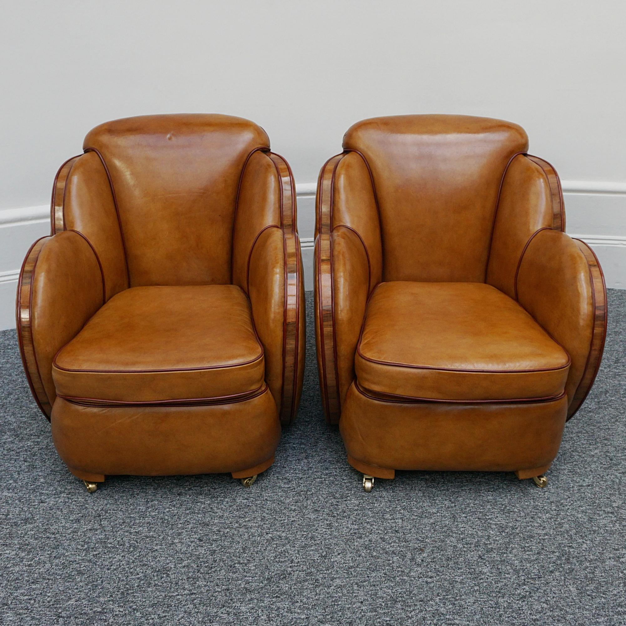 A pair of Art Deco cloud armchairs by Harry & Lou Epstein. Figured walnut banding with brown leather upholstery and crimson leather piping. Set over brass castors.

Dimensions:  H 79cm W 75cm D 70cm Seat H 43cm W 47cm D 59cm

Origin: English

Date: