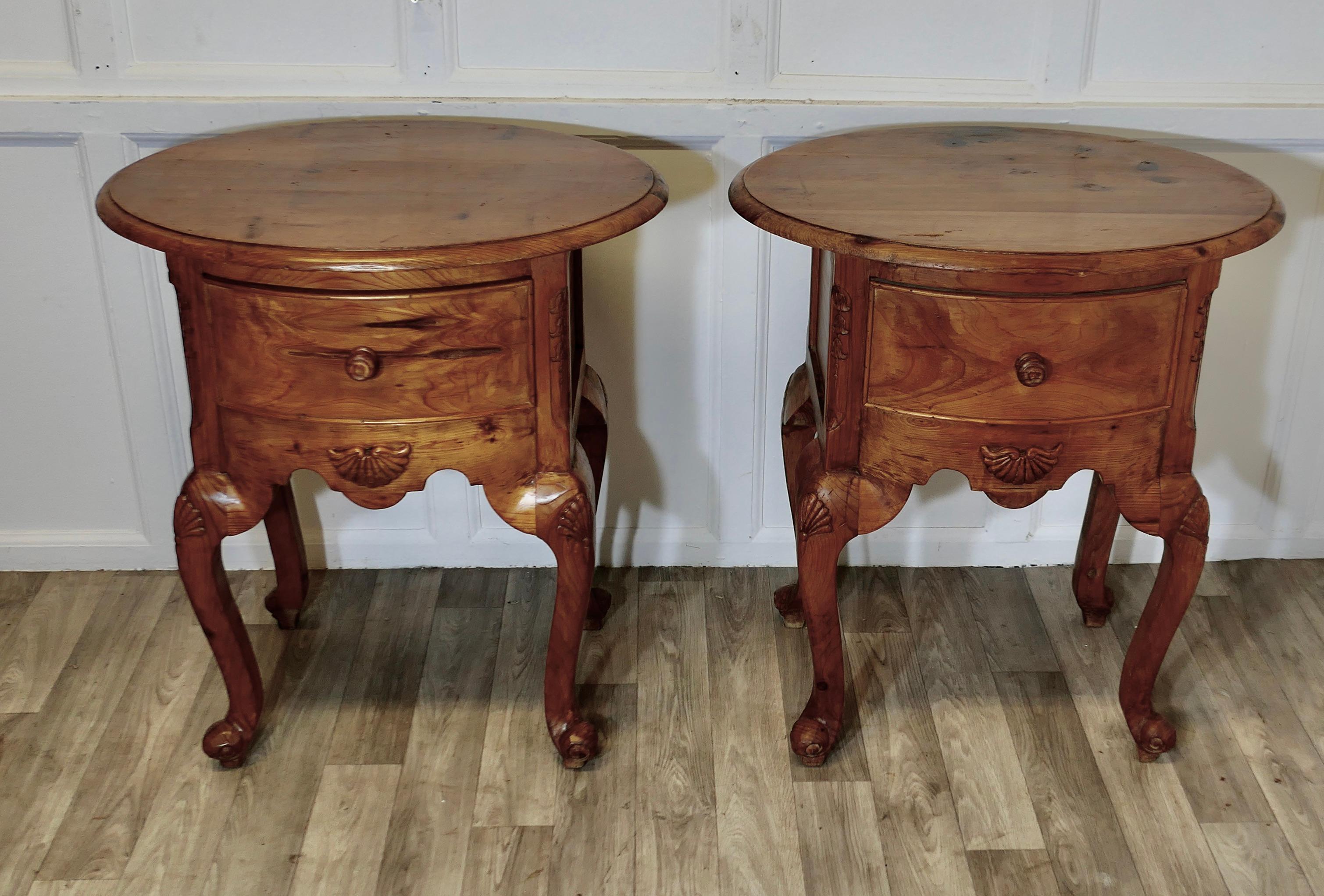 Paire de tables d'appoint ou de chevets en pin lourd  

Il s'agit d'une paire de tables de bonne qualité, les plateaux sont de forme ovale et ont une façade en arc de cercle avec un tiroir profond. Elles reposent sur de gros pieds cabriole.  
Les