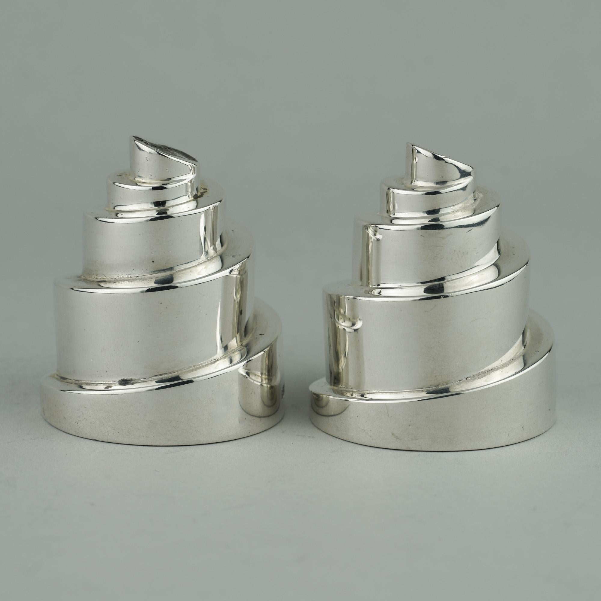 Sterling silver pair of salt & pepper shakers in a form of a Helter Skelter, made by Boodle & Dunthorne.
The tops pierced with 'S' and 'P'. 
Made in England, London, 2001
Fully hallmarked. 

Approx. dimensions: 
diameter x height: 4.6 x 5.5 cm