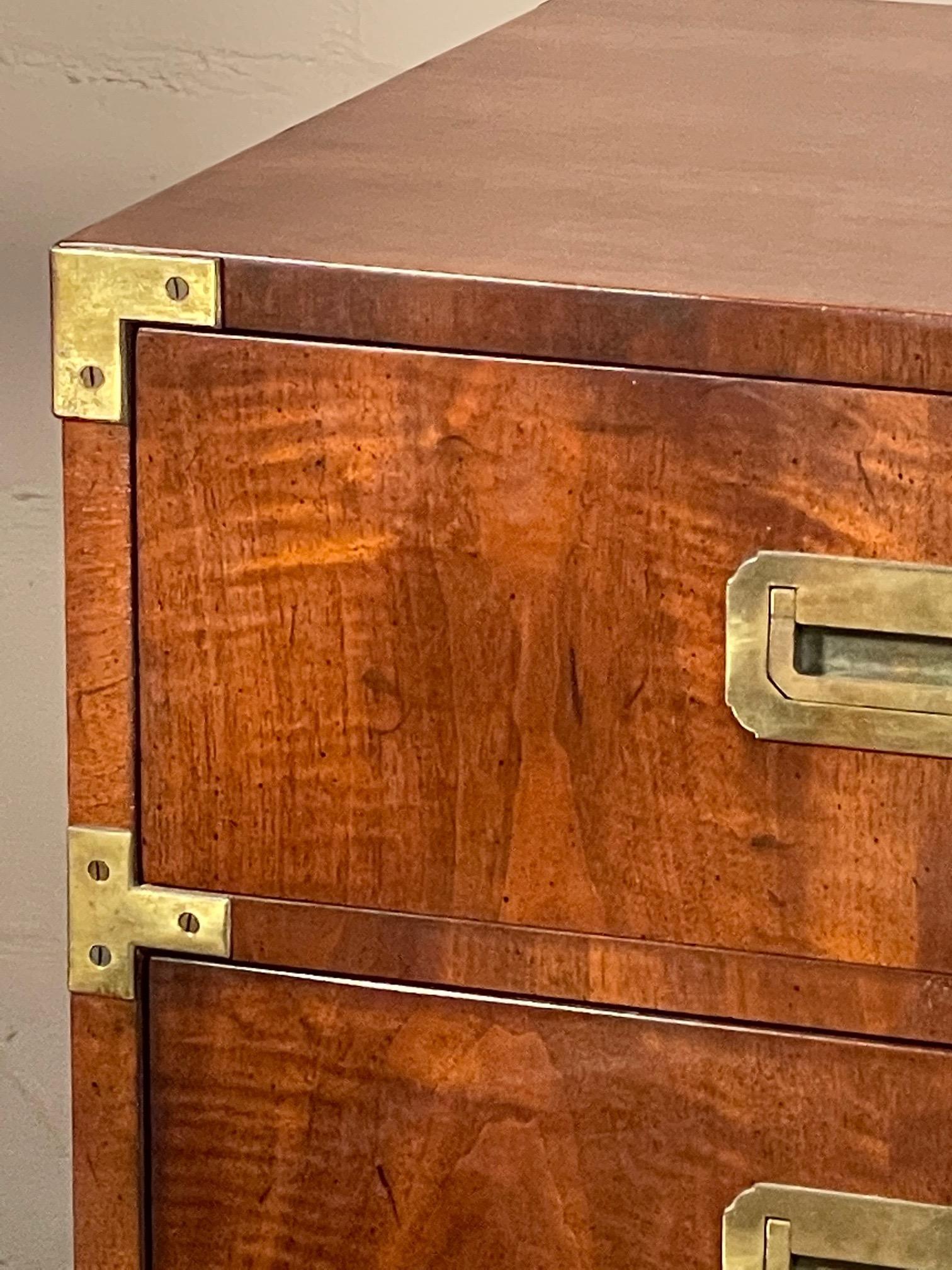 A pair of classic campaign style nightstands by Henredon. Three drawers with handles on the sides and finished backs. Very clean original finish and condition.