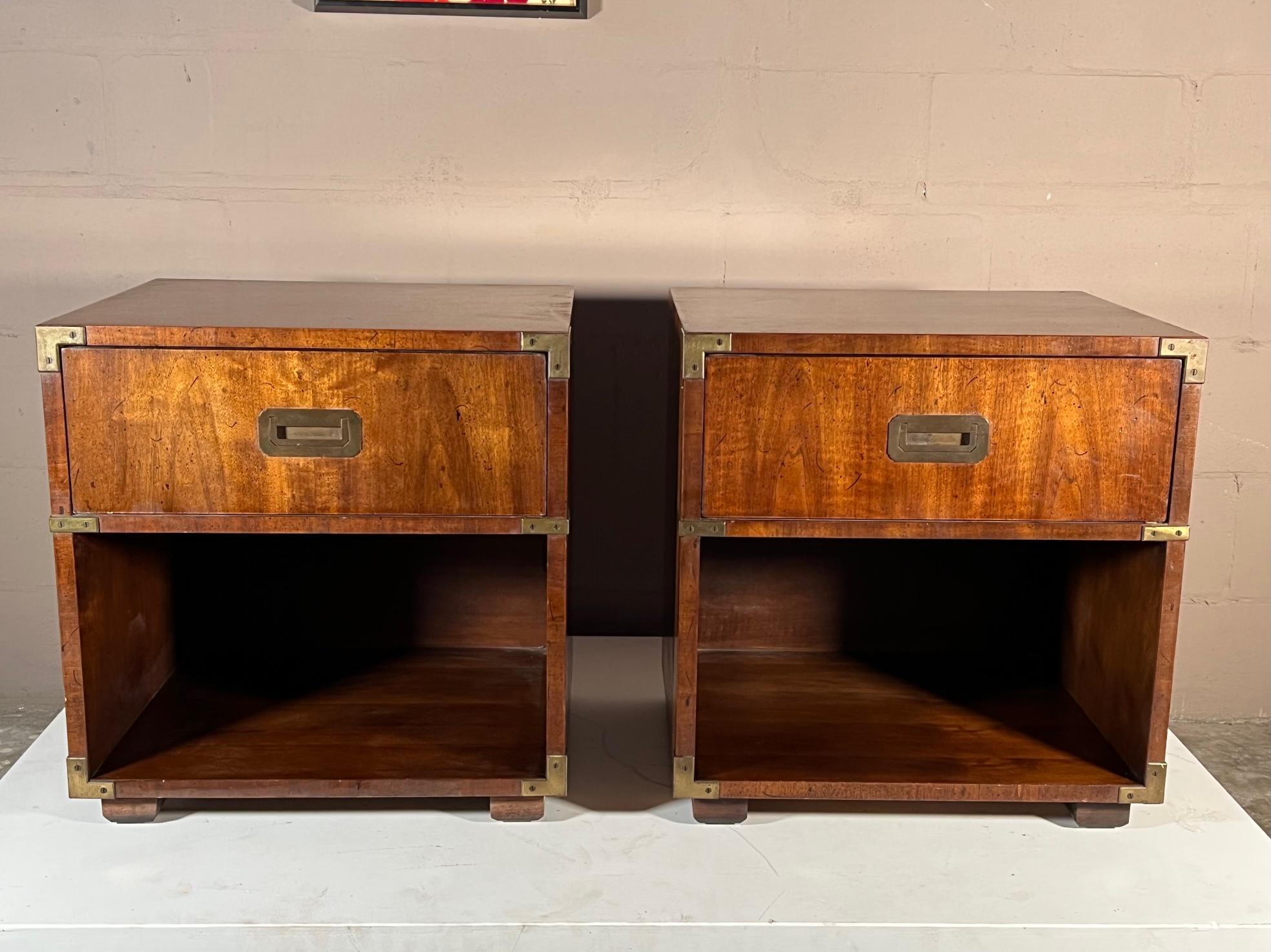 A pair of classic campaign style night stands by Henredon, ca' 1970's. Nice walnut with original finish, graining, heavy solid brass accents and handles.