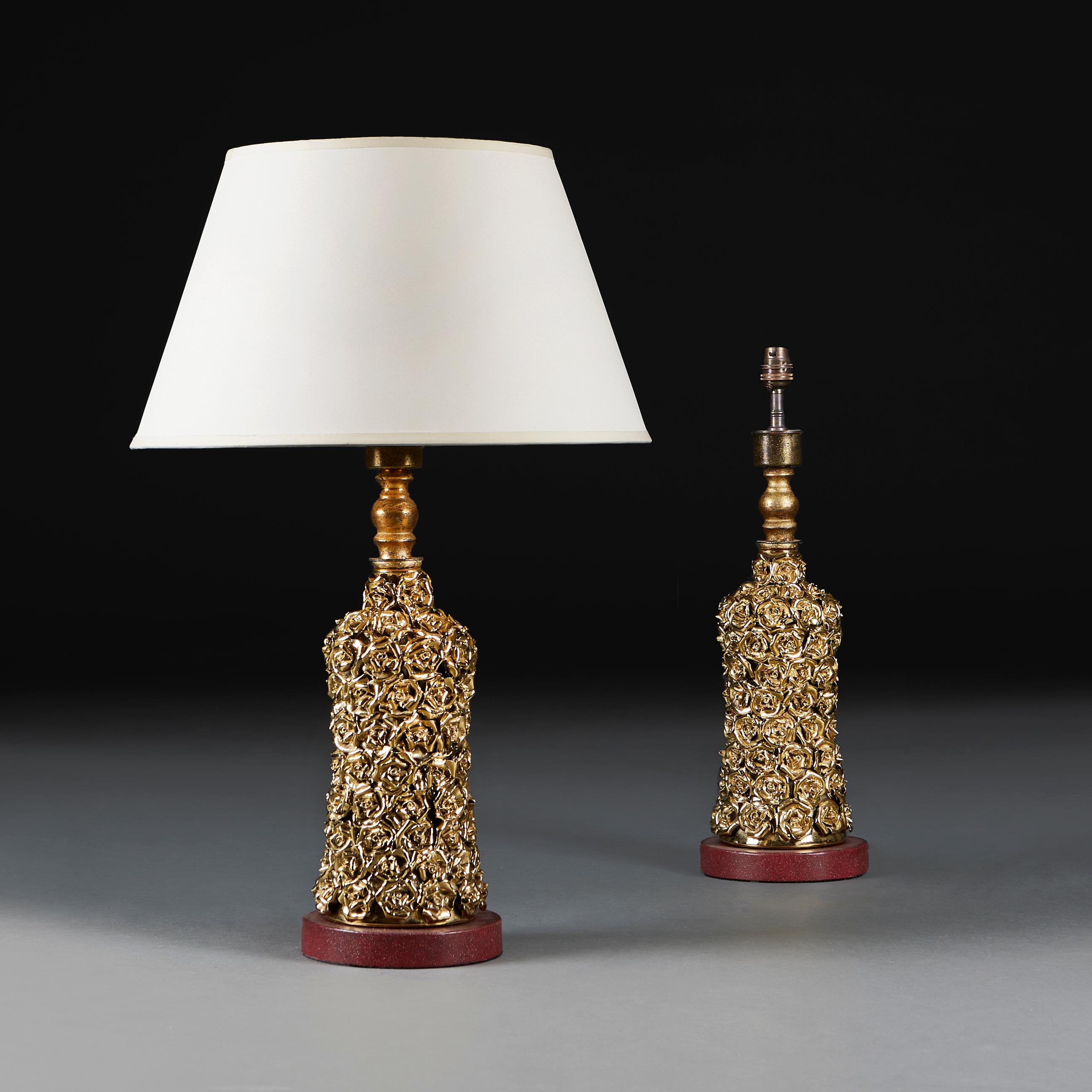 Italy, circa 1950
A unusual pair of mid twentieth century Hollywood Regency lamps, the bodies embellished with gilded porcelain roses throughout, and mounted on faux porphyry circular bases.

Height of lamp    41.00cm
Height with shade 