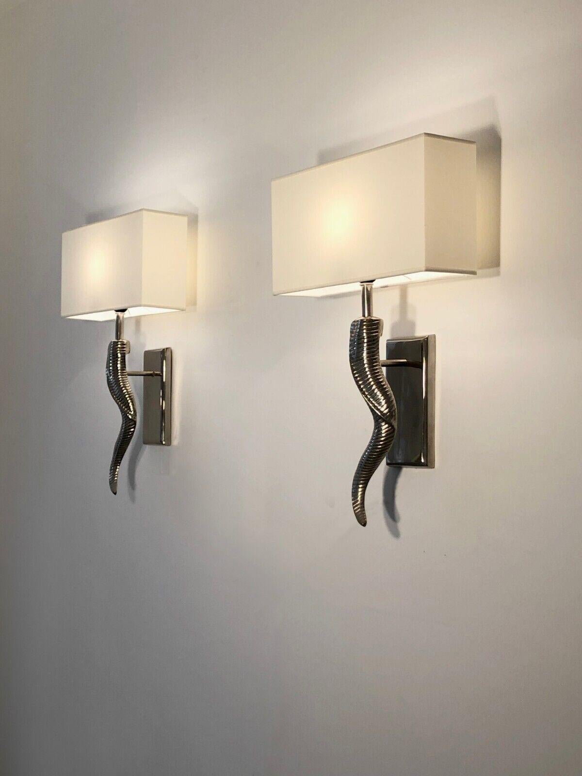 A spectacular and sculptural pair of wall appliques in form of the Horn, in polished aluminum, Shabby-Chic, Neoclassical; impressive organic Horn-like body in polished metal suspended on two rectangular bases, holding two rectangular shadows. To be