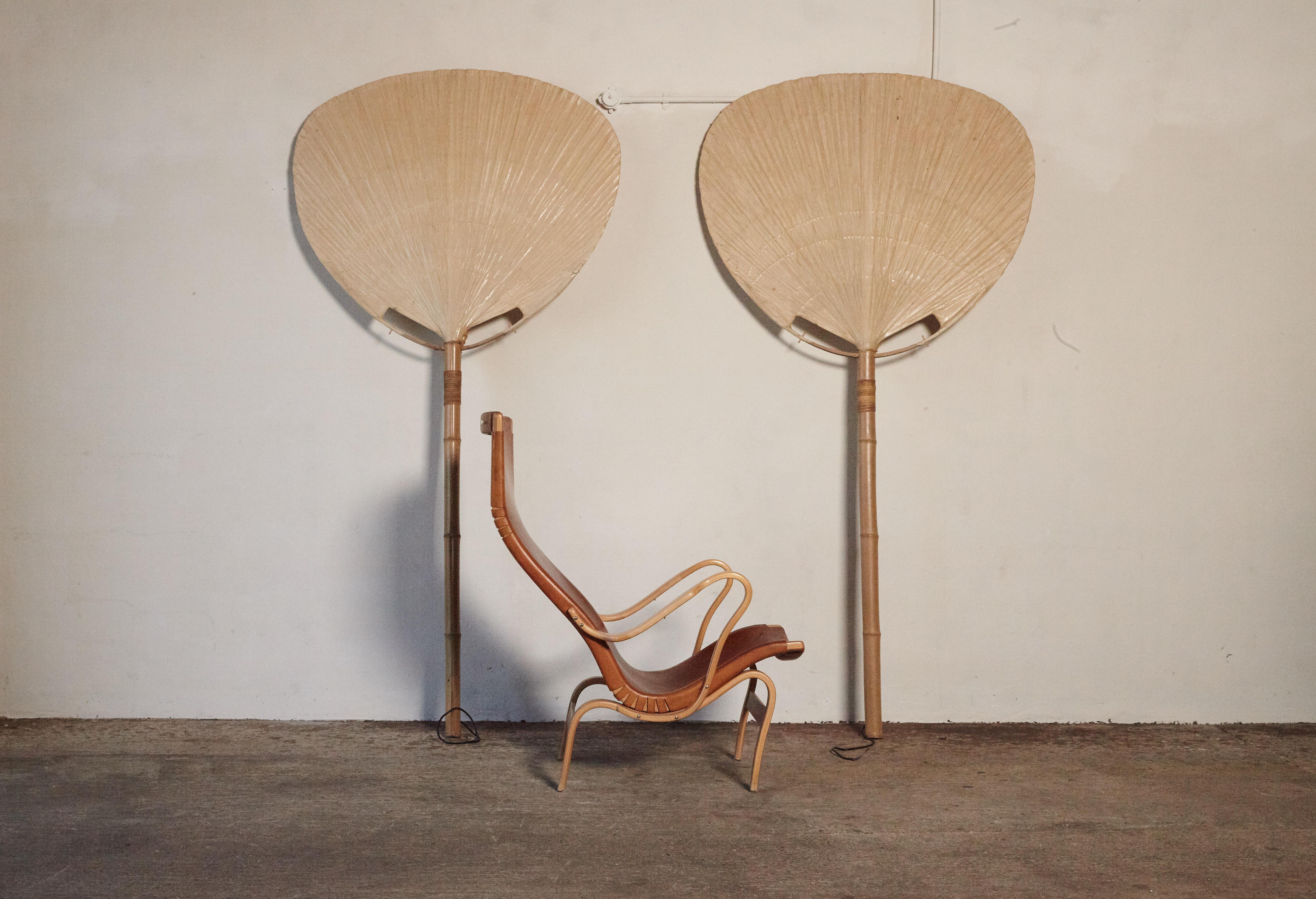Extremely rare pair of Uchiwa floor lamps, designed by Ingo Maurer for M design, Germany, in the 1970s. Handmade from bamboo, wicker and Japanese rice paper. The lamp is floor and wall leaning or can be wall-mounted. There are 3 bulb sockets on each