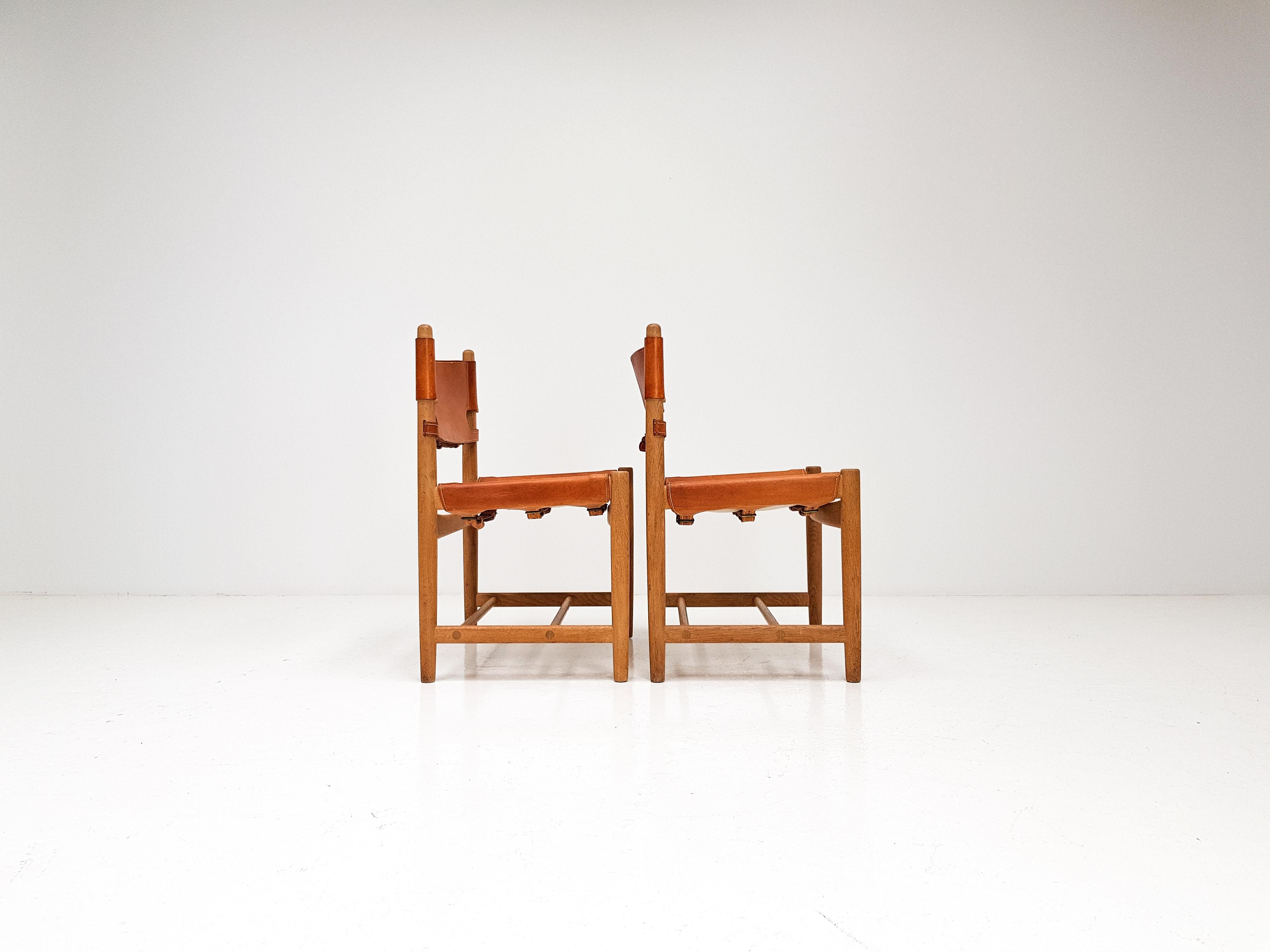 A pair of stunning 'Hunting' chairs Model 3237 by Børge Mogensen and produced by Fredericia Furniture, Denmark, 1960s.

Both the oak and cognac patinated saddle leather have aged wonderfully and whilst having plenty of character the chairs are in