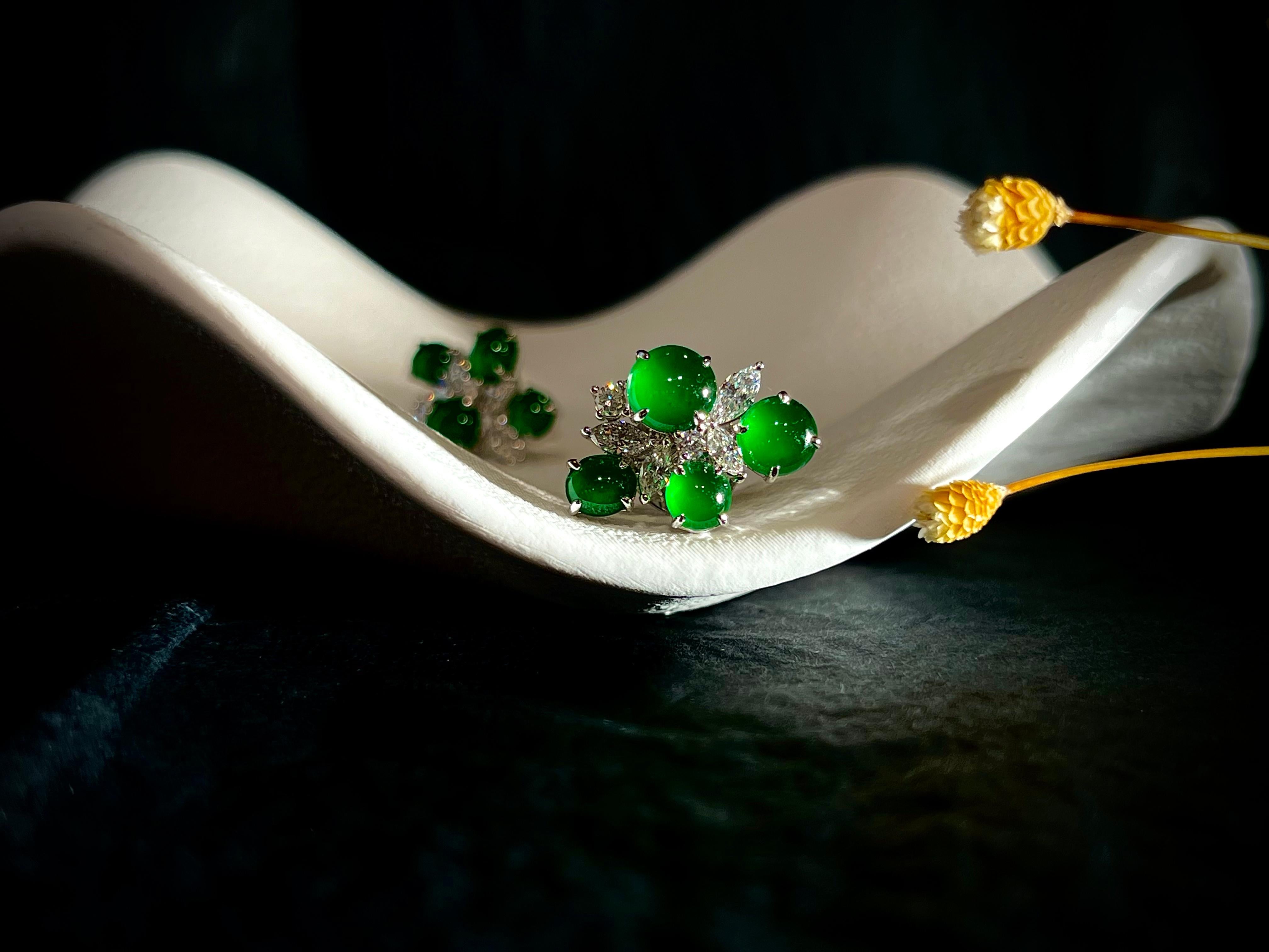 A pair of very fine jadeite and diamond earrings of exceptional translucency, each side set with four natural jadeite jade cabochons of brilliant emerald green colour, decorated with natural brilliant cut diamonds weighing 0.128 carats and marquise