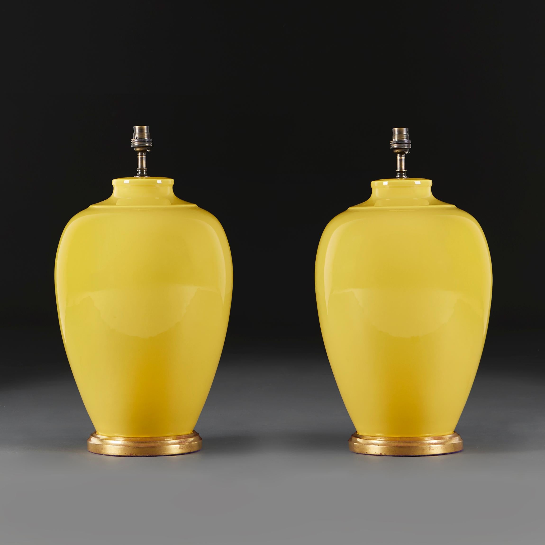 A pair of twentieth century imperial yellow baluster vases of large scale on giltwood bases, now mounted as lamps.

Please note:

Lampshade not included. Lamp photographed with a 18” diameter pale cream card Pembroke lampshade.

Currently wired for