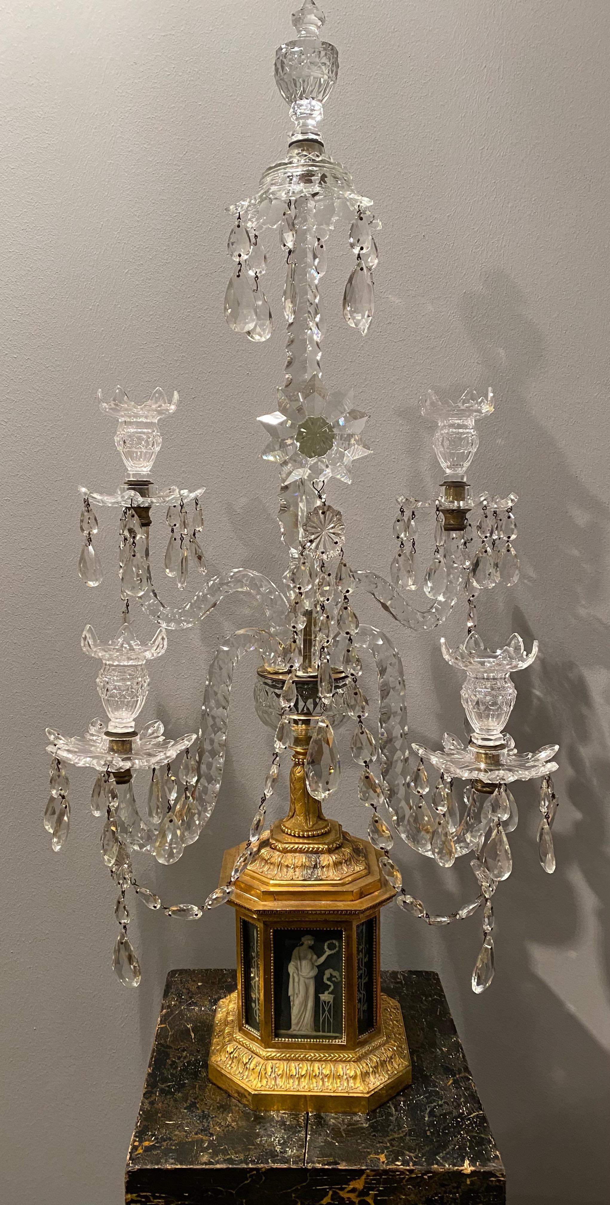 A pair of important and highly unusual candelabra from the 1780s. The bases are made of gilt bronze with inserted, glasscovered paintings. The paintings are by Piat-Joseph Sauvage (1744-1818). They are depicting different classical figures and