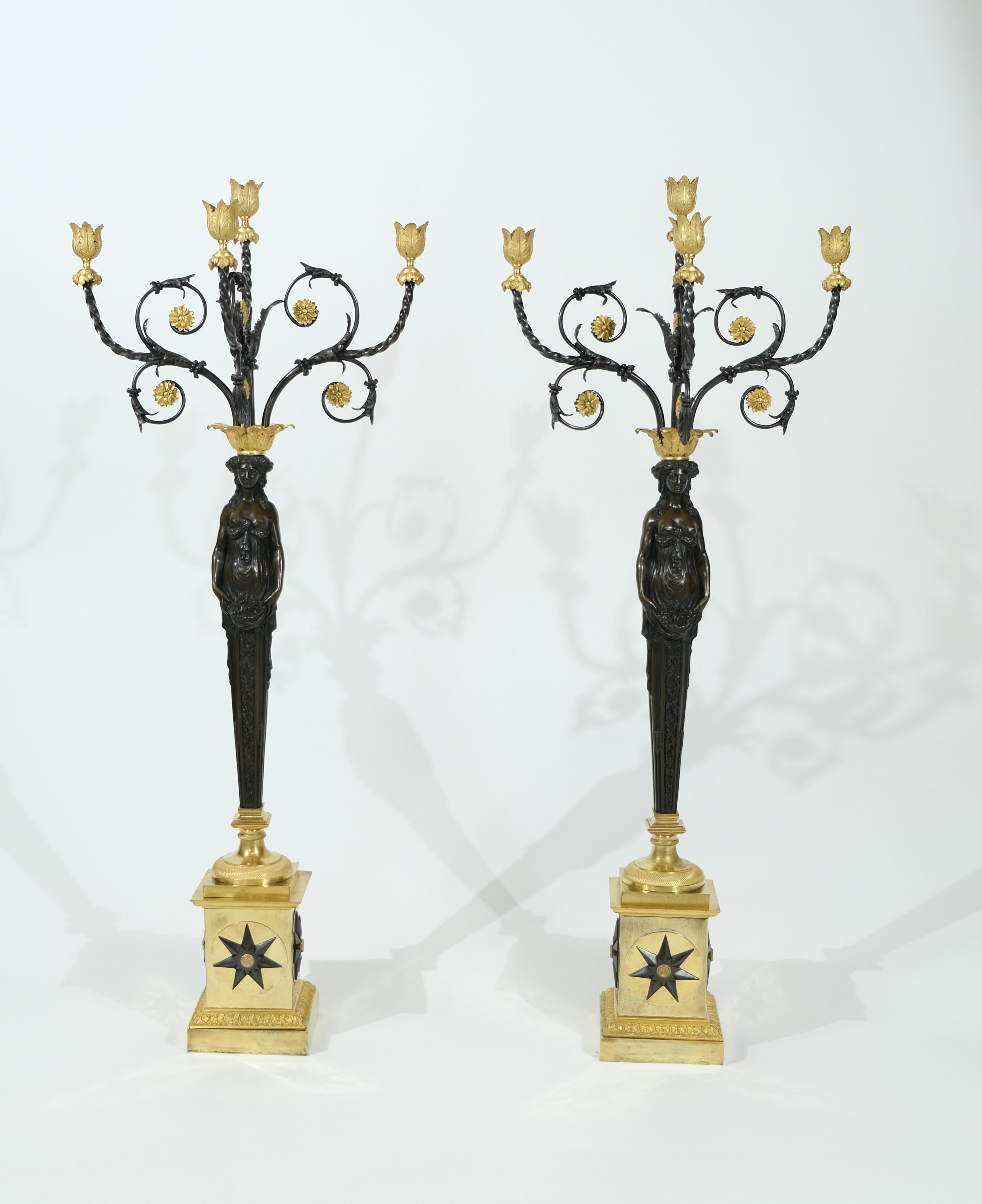 Ein Paar vergoldete und schwarz patinierte Bronzekandelaber, 99 cm hoch. Es handelt sich um ein ungewöhnliches Modell mit großen schwarzpatinierten Göttinnen, die vier Arme mit Kerzenhaltern auf dem Kopf halten. Die Qualität des Gusses ist sehr hoch