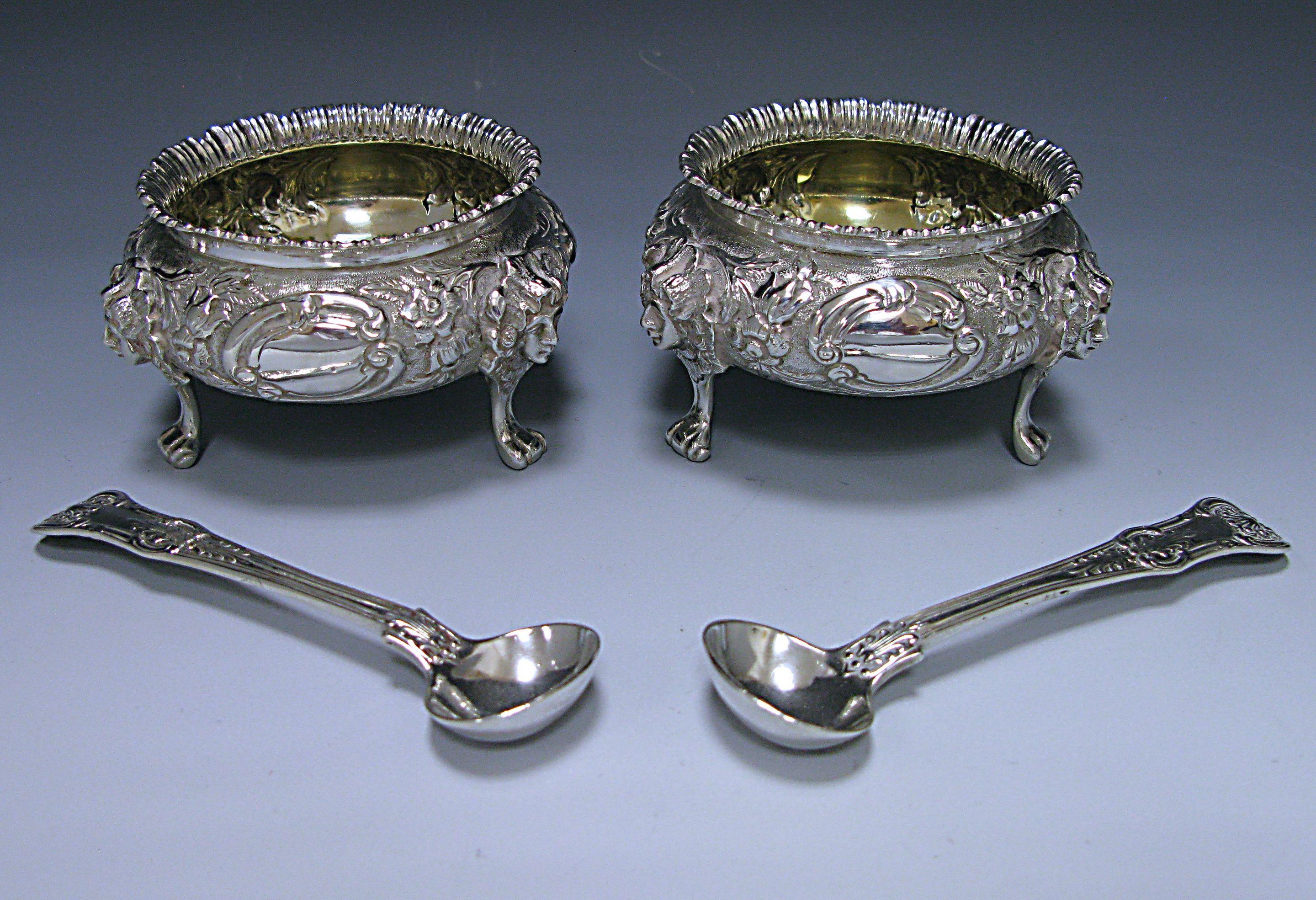 A pair of impressive Victorian antique silver salts of circular rounded cauldron form in the Rococo style. The Salts Stand on masked lion paw feet and have vacant cartouches. The interior of the salts is gilt. The salts have matching condiment