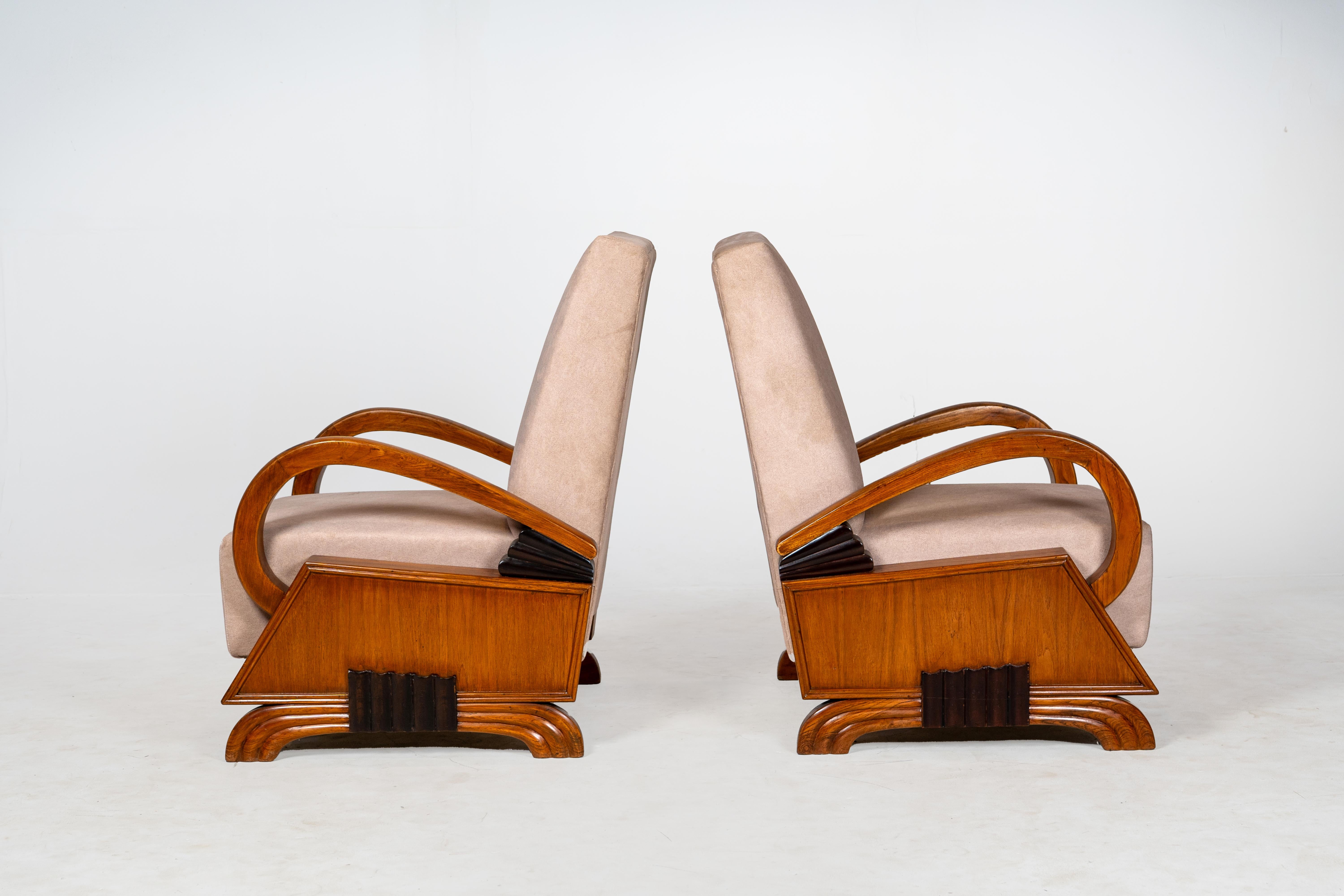 Este clásico par de sillones de salón Art Decó vintage presenta unos llamativos brazos curvados de madera maciza, laterales de teca encajonados y distintivos detalles geométricos negros en la base, distintivos del sofisticado diseño de la época. Los