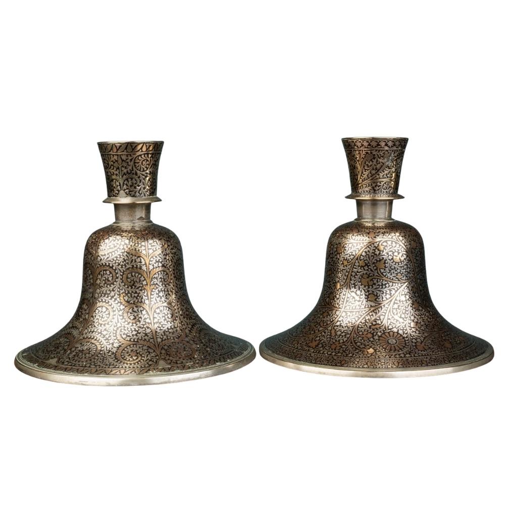A pair of Indian Mughal silver and brass inlaid candlesticks, converted from Hookah bases. Circa1900

Dimensions:
Height 22cm
Diameter 23cm

