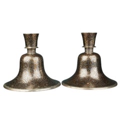 A pair of Indian Mughal silver and brass inlaid candlesticks