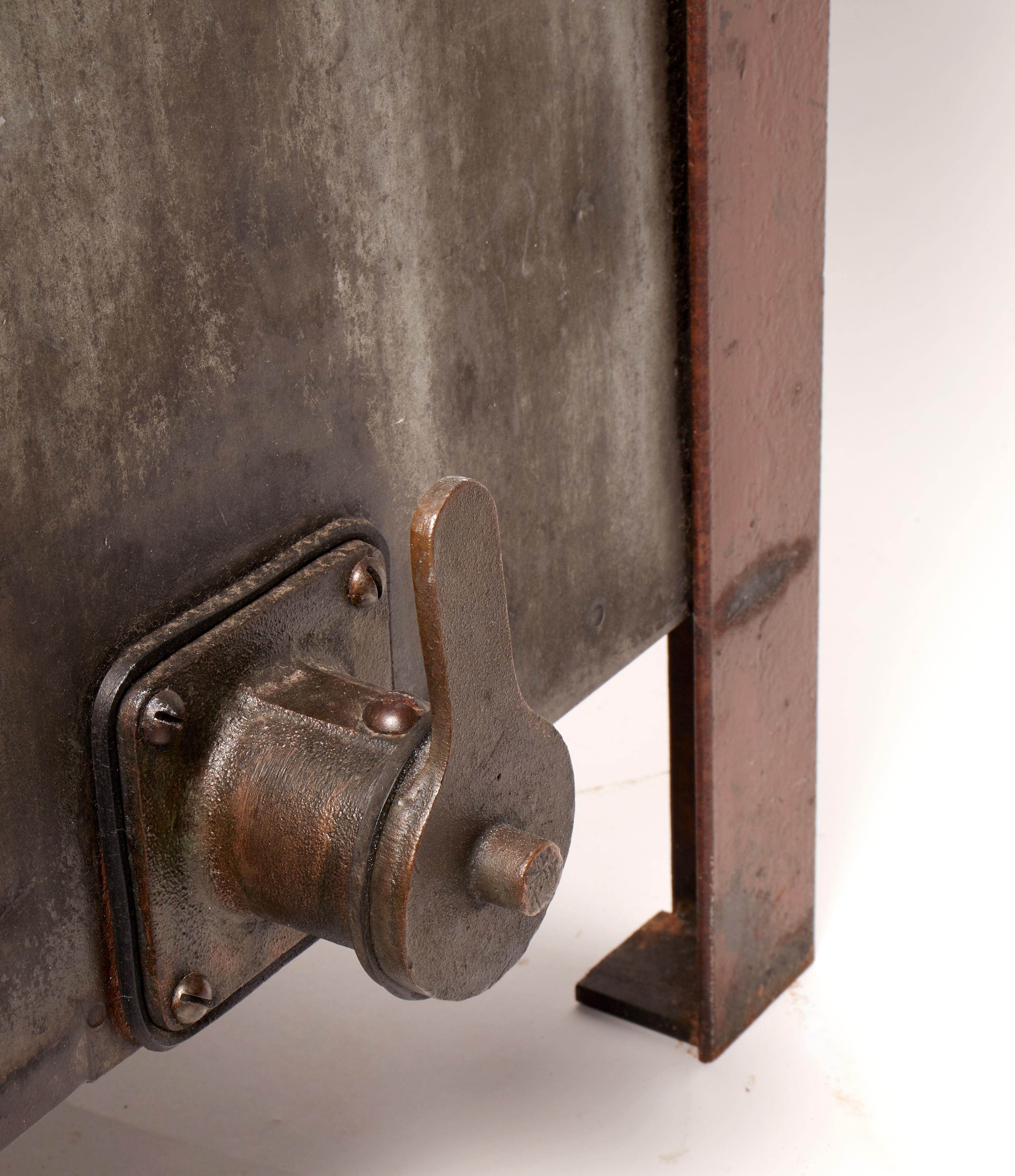 A pair of metal industrial oil containers with faucet, reused as flower boxes or garden terrace USA, circa 1900.