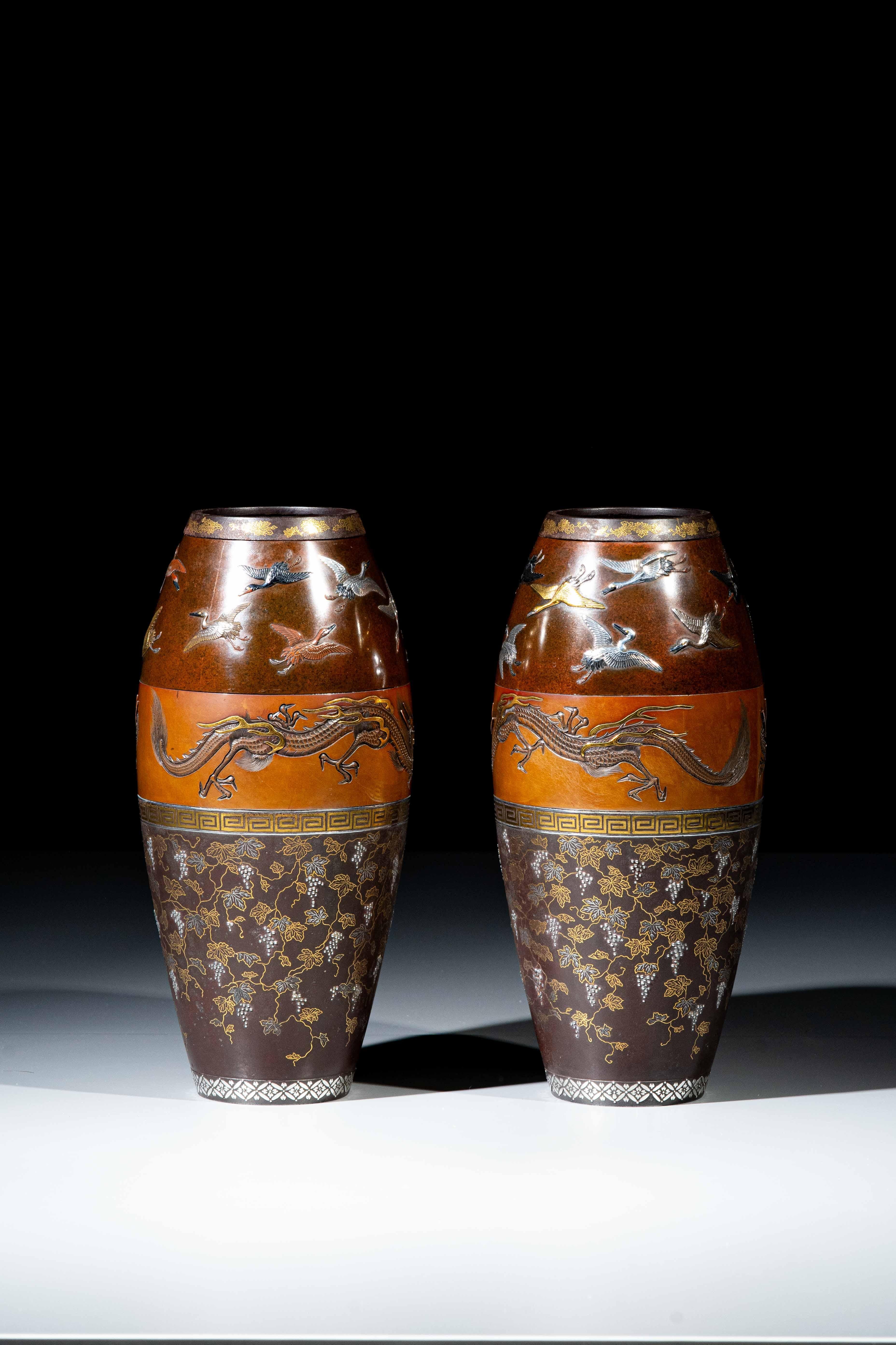Paire de vases en fer et en bronze, avec des incrustations de nunomezogan en or et en argent, ainsi que des incrustations en relief de shishiaibori et de iro-e takazogan en shibuichi et shakudo, signées Hamada Sei. La bande supérieure représente de