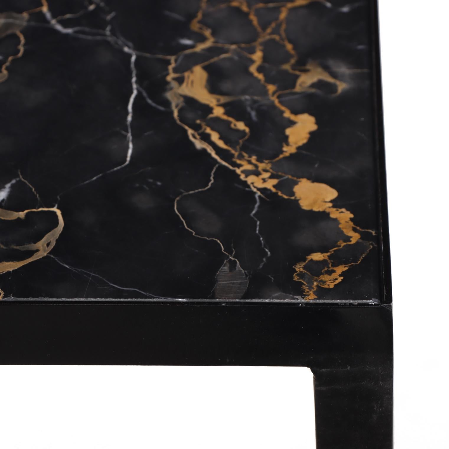Un refinado par de consolas contemporáneas, cada una de ellas con una base de hierro ennegrecido de forma lineal minimalista que sostiene un tablero vintage de mármol Nero Portoro ricamente veteado, un material exquisito (recuperado y reutilizado de