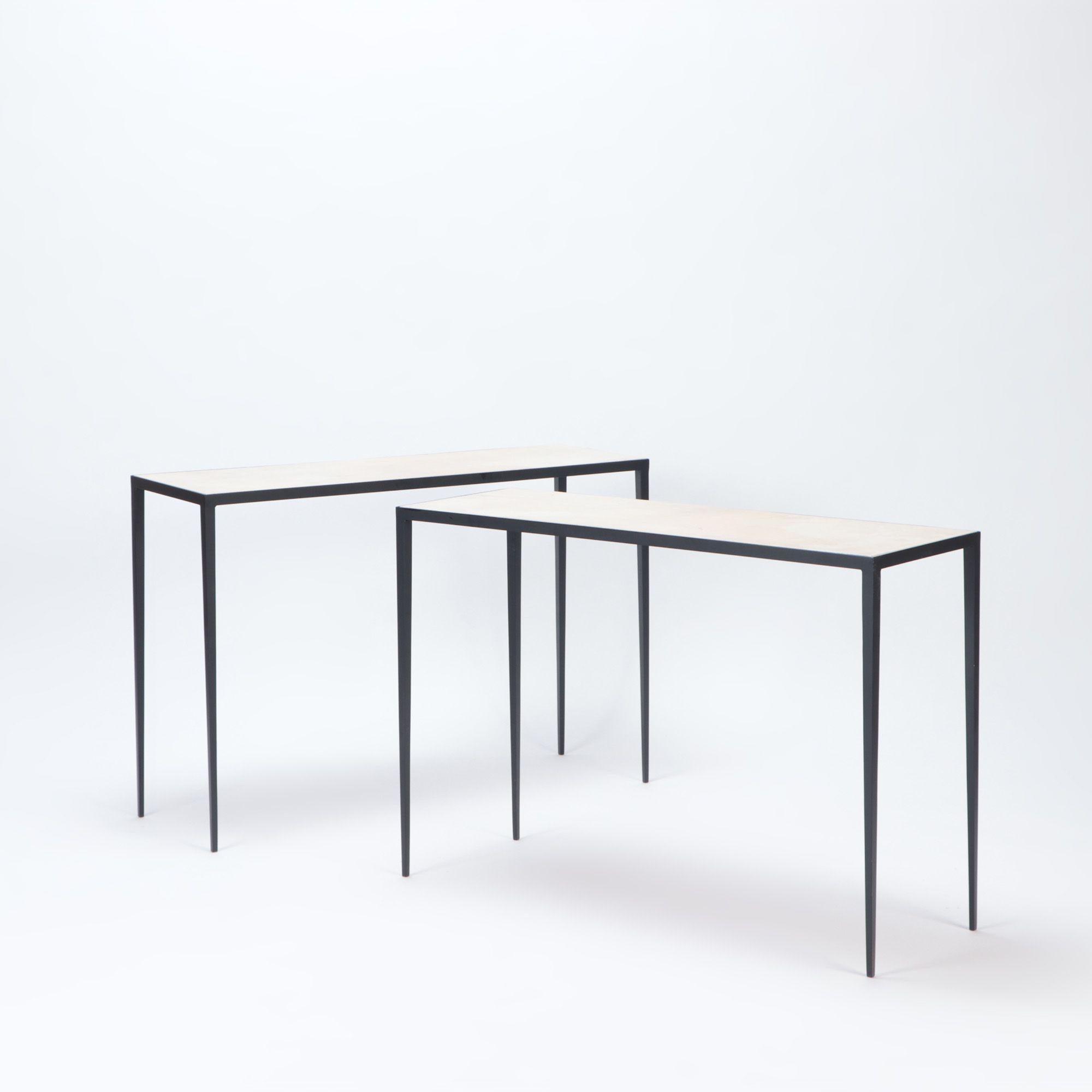 A pair of iron and parchment consoles with parchment tops fitted onto slender matte black wrought iron bases. In the manner of Jean-Michel Frank. Contemporary.