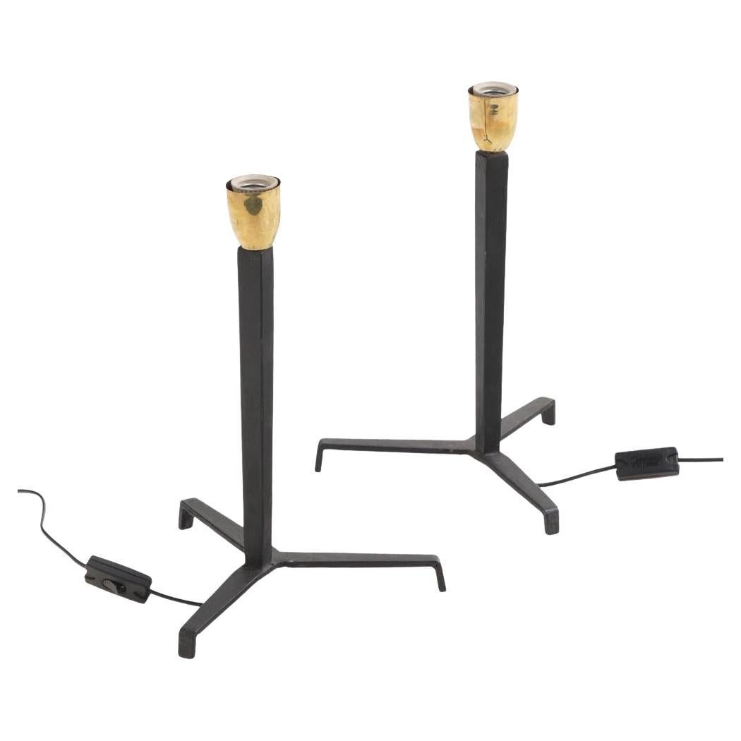 A pair of iron tripod table lamps in the manner of Jean-Michel Frank.
