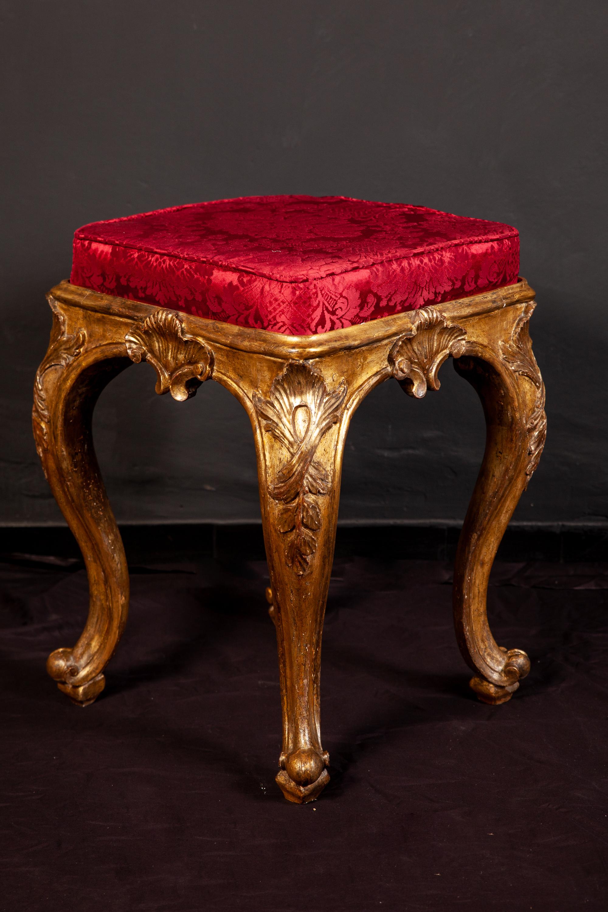 These finely carved and gilded square stools add a beautiful touch to your living spaces. They are carved on all four sides with elegant cabriole legs. 
Excellent condition of gilding. Red silk upholstery in a perfect condition. Provenience from a