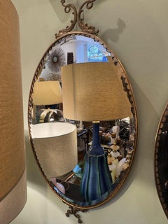 A pair of Italian 1940s oval mirrors with dolphin detailing around the frame