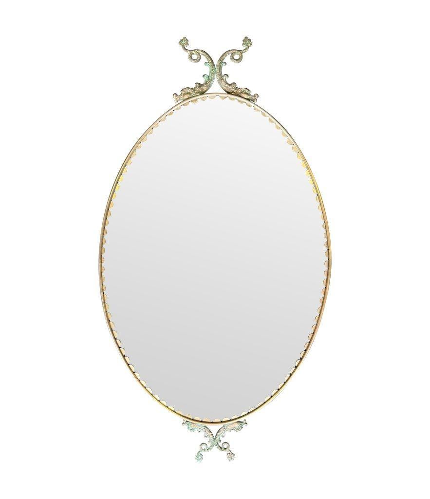 Art déco Paire de miroirs ovales italiens des années 1940 avec détails en forme de dauphin autour du cadre en vente
