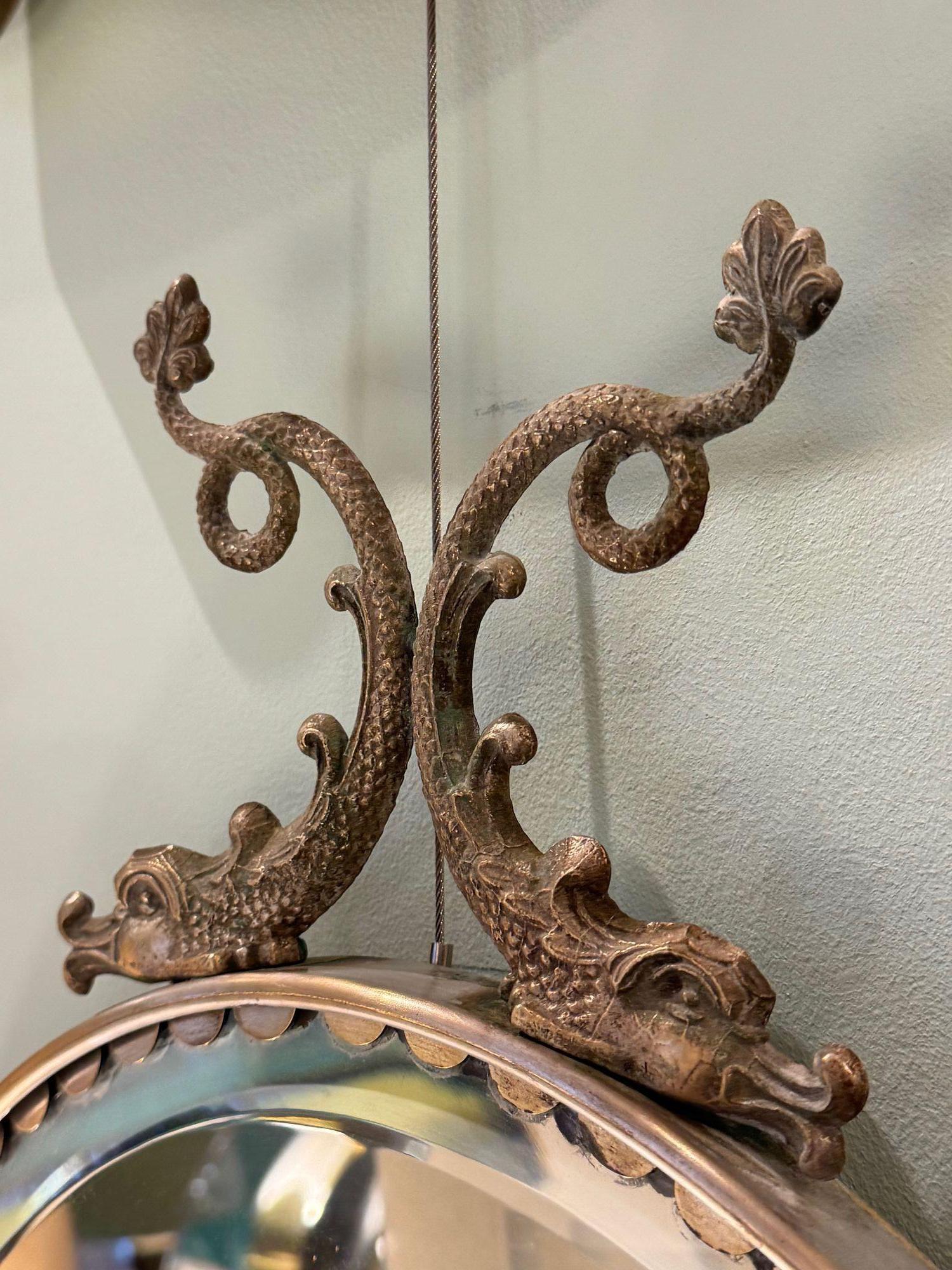 Milieu du XXe siècle Paire de miroirs ovales italiens des années 1940 avec détails en forme de dauphin autour du cadre en vente