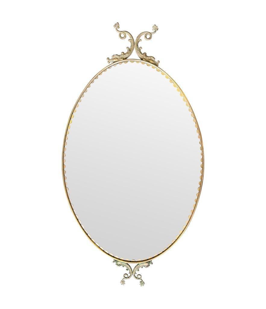Laiton Paire de miroirs ovales italiens des années 1940 avec détails en forme de dauphin autour du cadre en vente