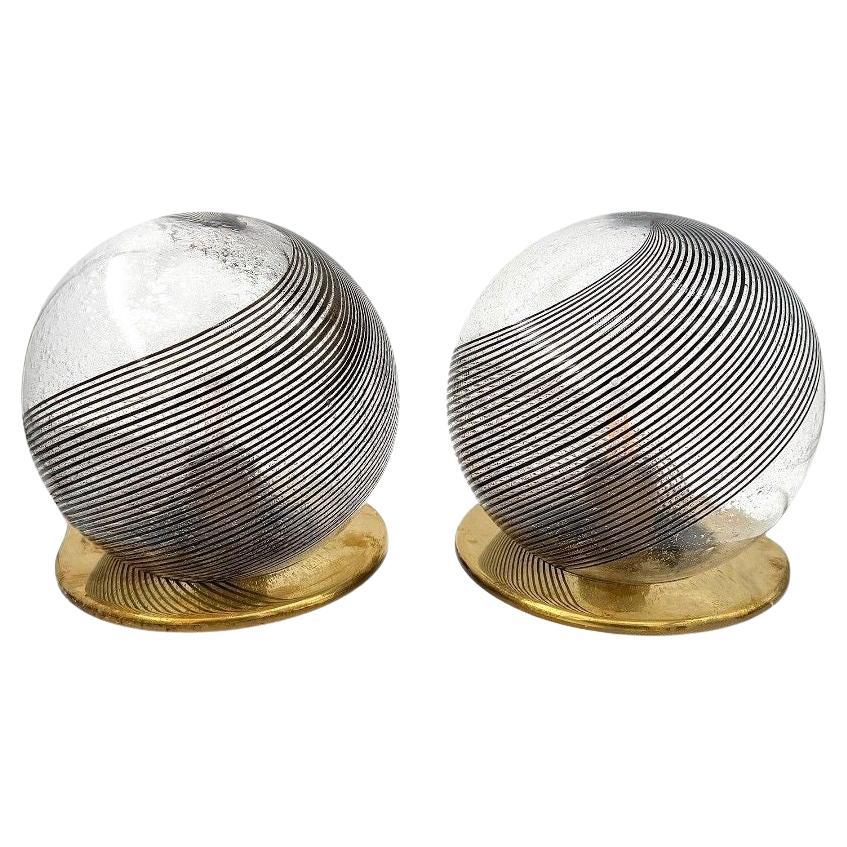 A pair of Italian 1970s smoked Murano glass swirl ball lamps with brass bases For Sale