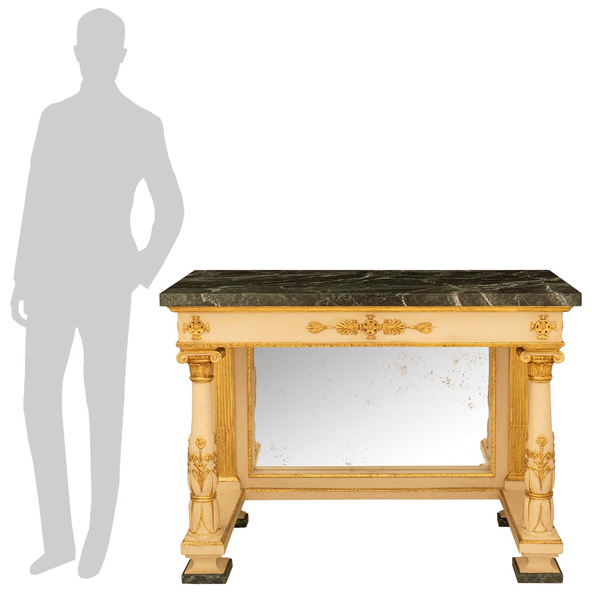 

A handsome pair of Italian 19th century Neo-Classical st. patinated off white and giltwood consoles. The pair of freestanding consoles are raised by faux painted marble blocks and concave supports. The front circular tapered columns are elegantly
