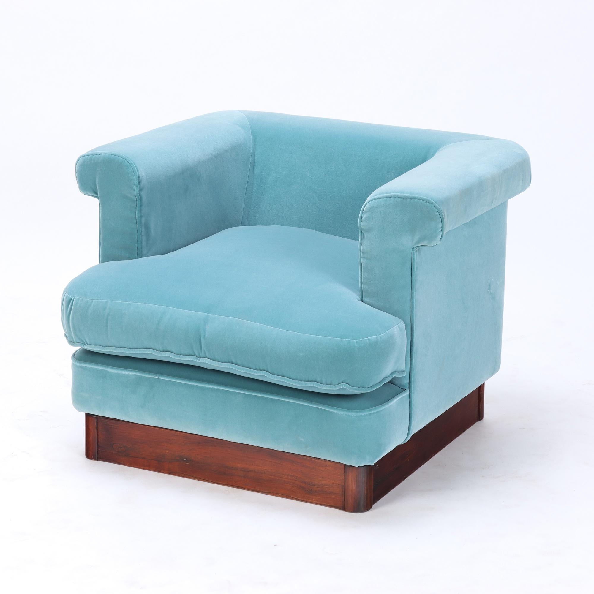 A pair of glamorous Italian blue velvet upholstered cube/club chairs, resting on a wood base. C 1970.