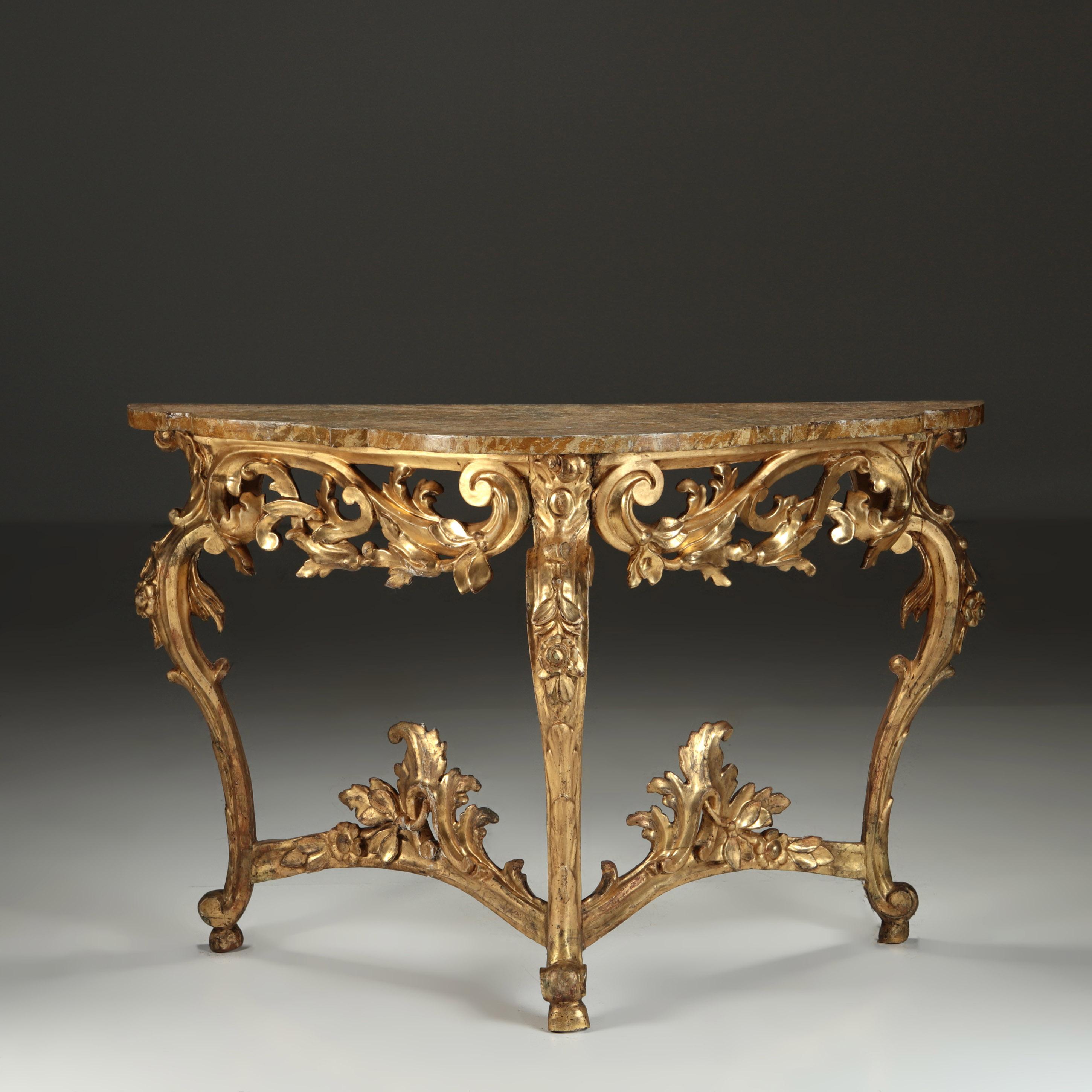 ITALIAN CONSOLES, circa 1800

A pair of carved gilt wood Italian console tables, the tri-form bases are delicately carved with trailing flowers and garlands, presented with their original painted faux Siena marble tops.
