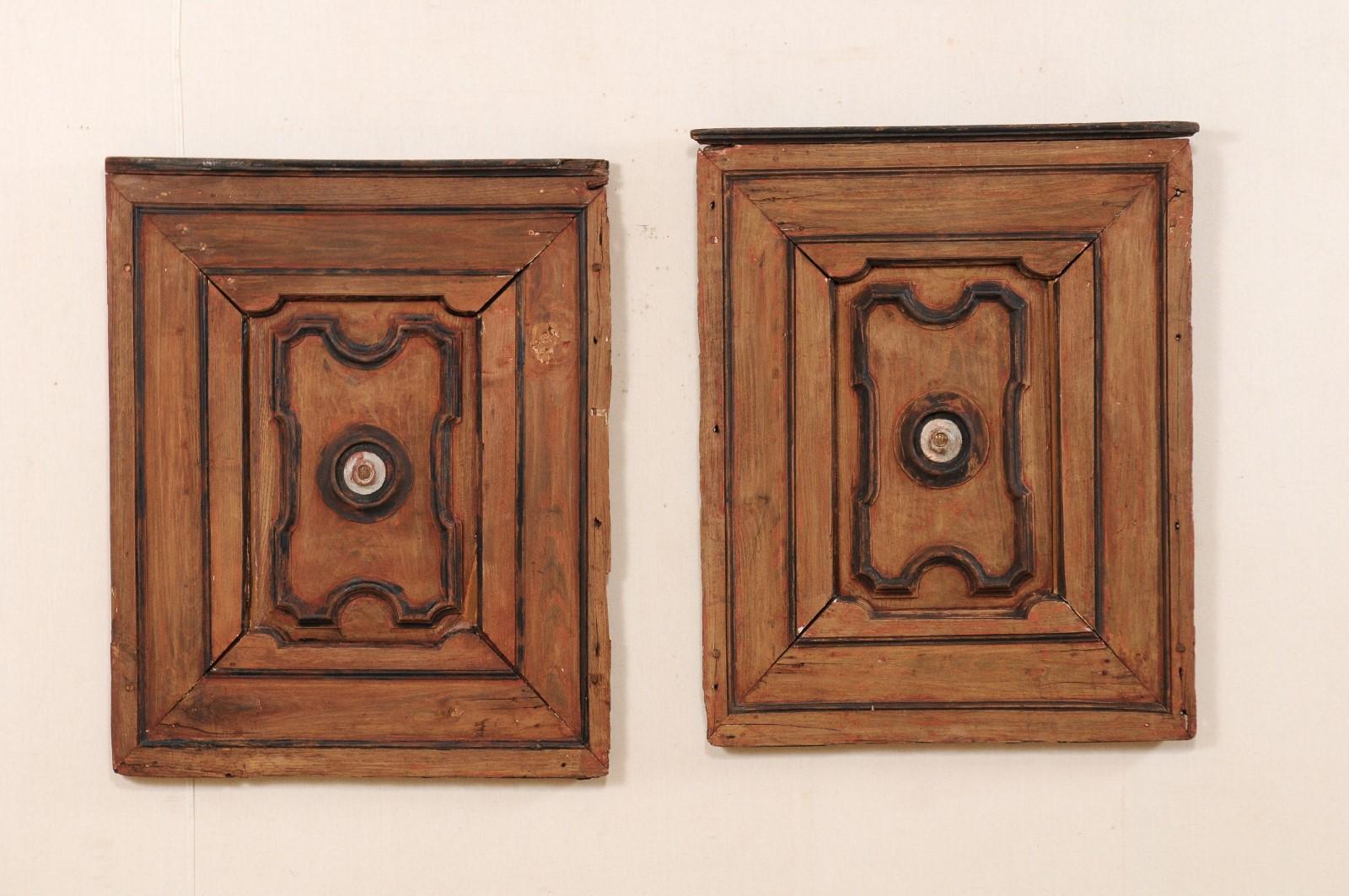 A pair of Italian decorative wall panels from the turn of the 18th and 19th century. This pair of antique wall decorations from Italy, each approximately 3 feet in height, feature a molded frame with raised panel center with curvy geometric shape