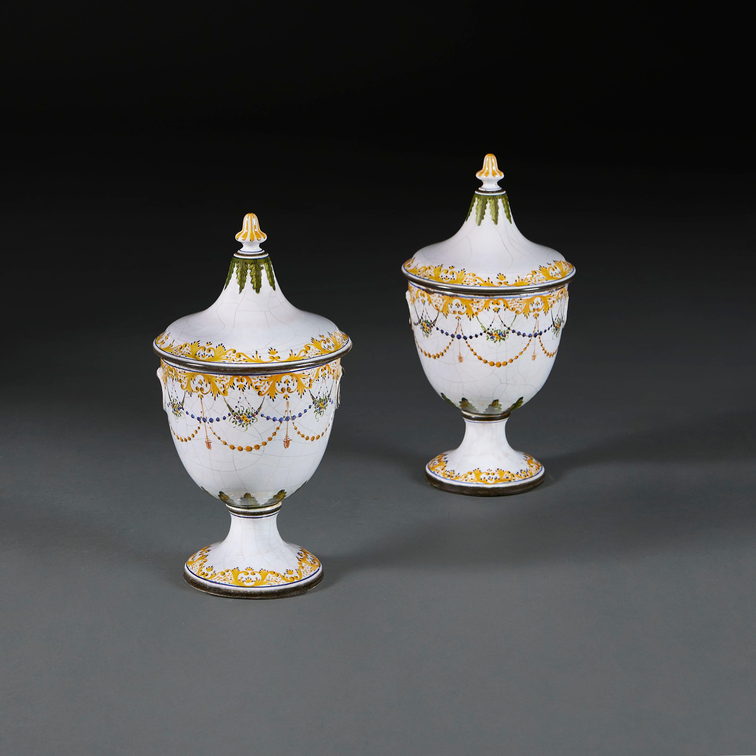 Italy, 1920

A pair of Italian faience chestnut urns, with white craquelure ground decorated with foliate garlands, scrolling yellow borders and green foliage, surmounted by a striped finial. 

Height 32.00cm
Diameter 16.00cm