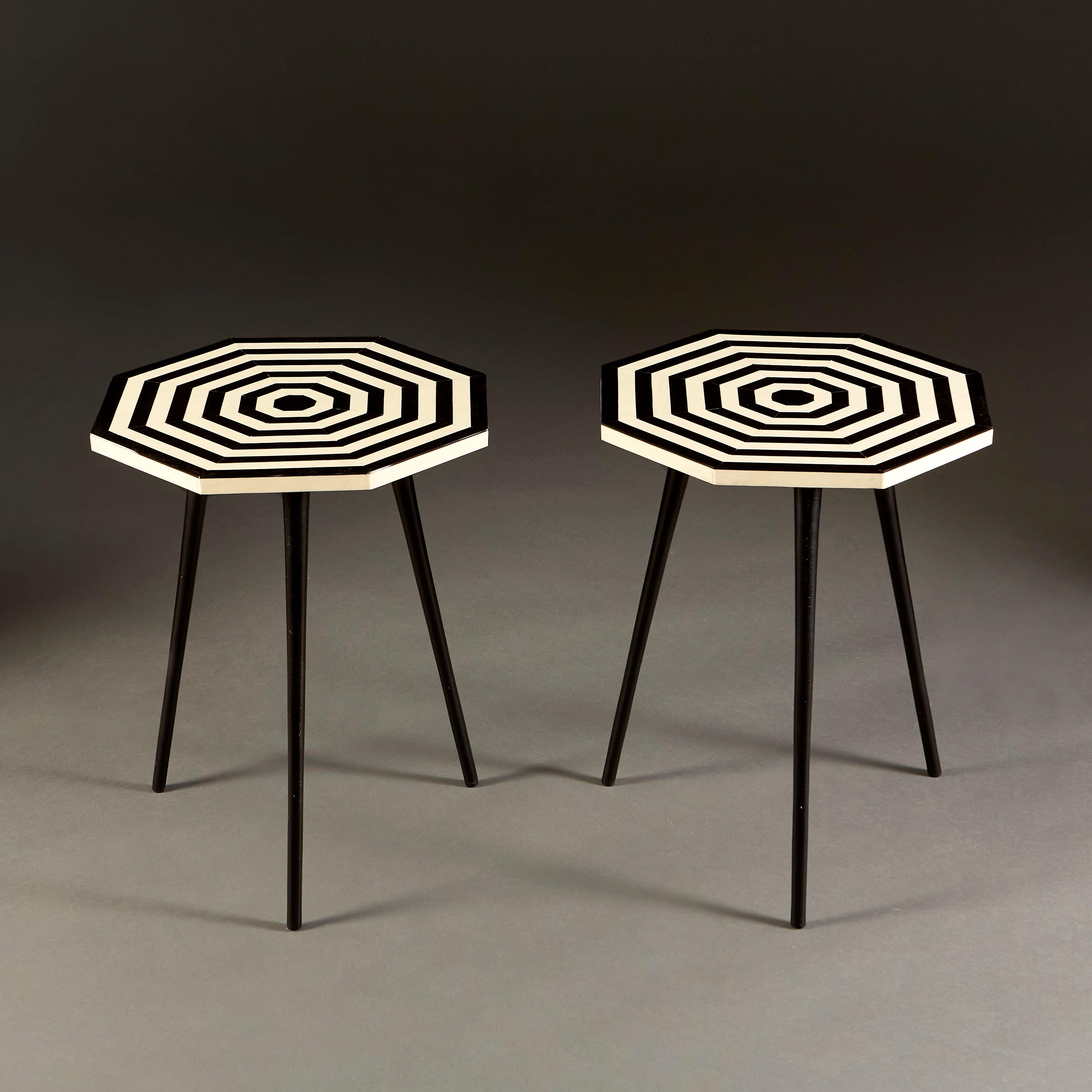 A pair of 1970s occasional tables with octagonal tops with concentric black and white striped pattern forming a bullseye, all supported on a tripod base. 

 